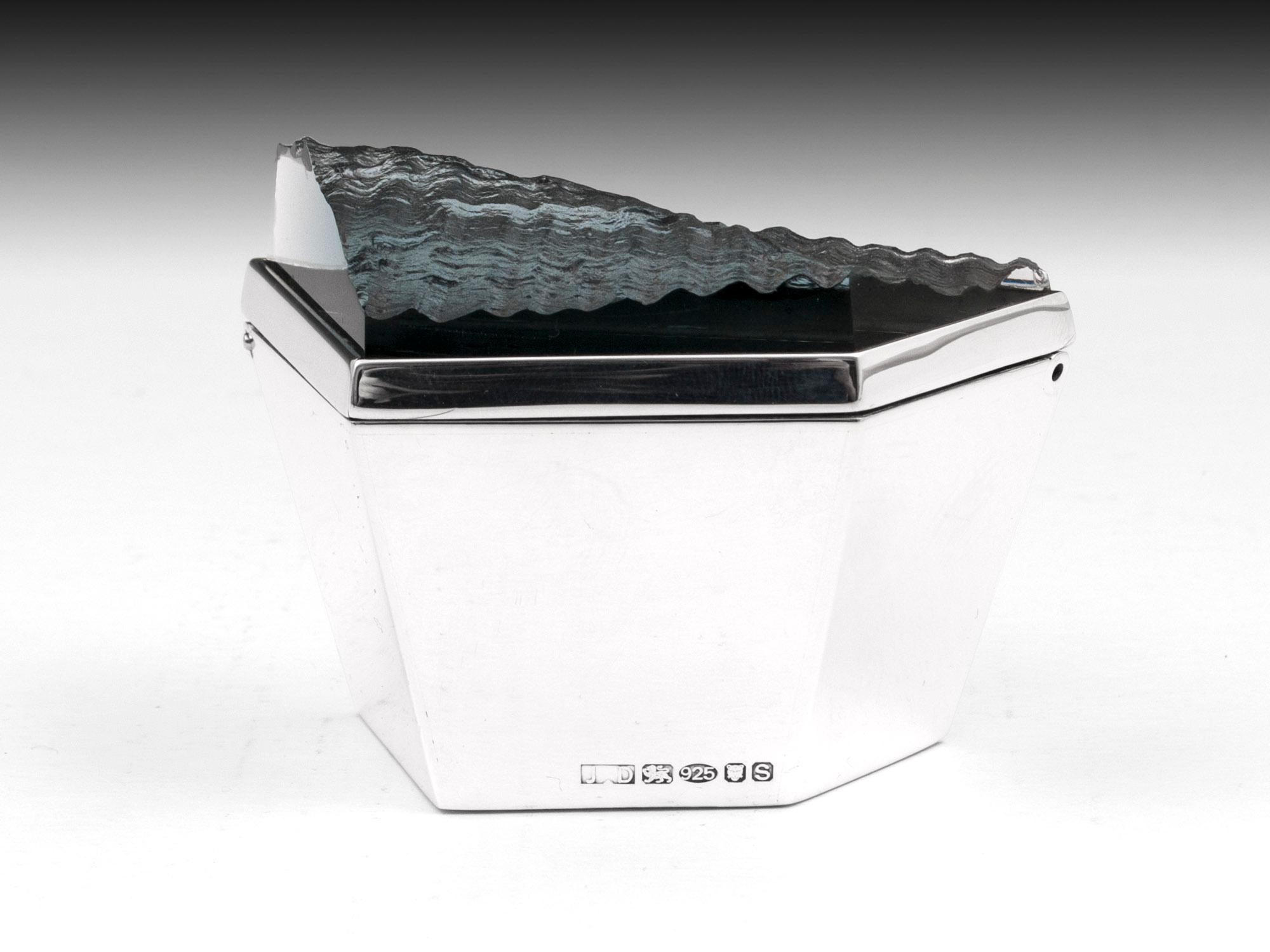 Contemporary sterling silver box with beautiful ripple glass top by award winning London Silversmith James Dougall. 

The lid opens to reveal polished blue stained Maple.

Fully hallmarked for London Assay office and bearing the unique makers