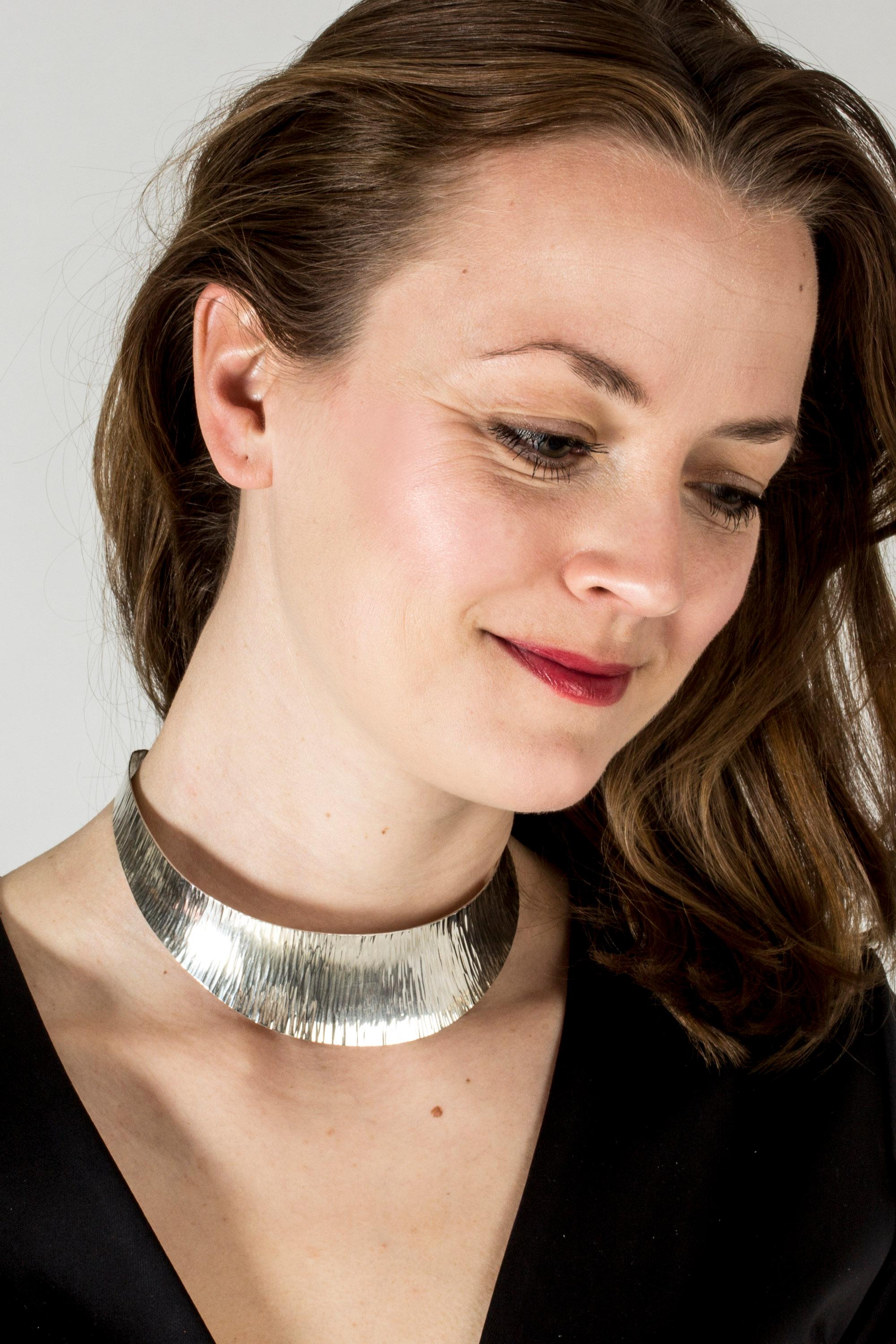 Striking, wide silver neckring by Waldemar Jonsson. The striped pattern catches the light from different angles and makes the piece stand out in its simplicity.