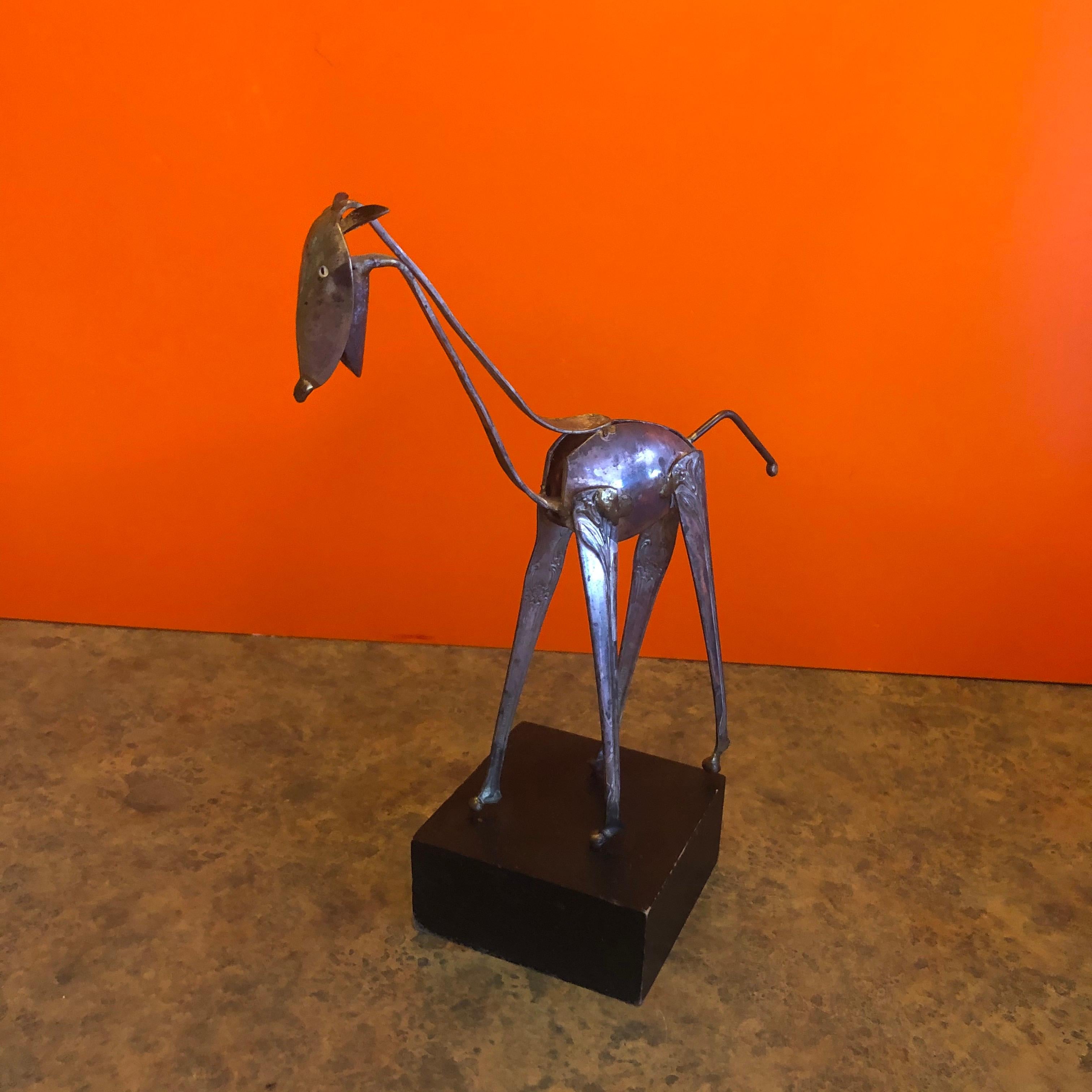 Modern silver plate spoon giraffe sculpture by Raul Zuniga for Casa Del Arte, circa 1971.
 
The whimsical piece is made from silver plated spoons and various found household objects of copper. The sculpture is mounted on a 4