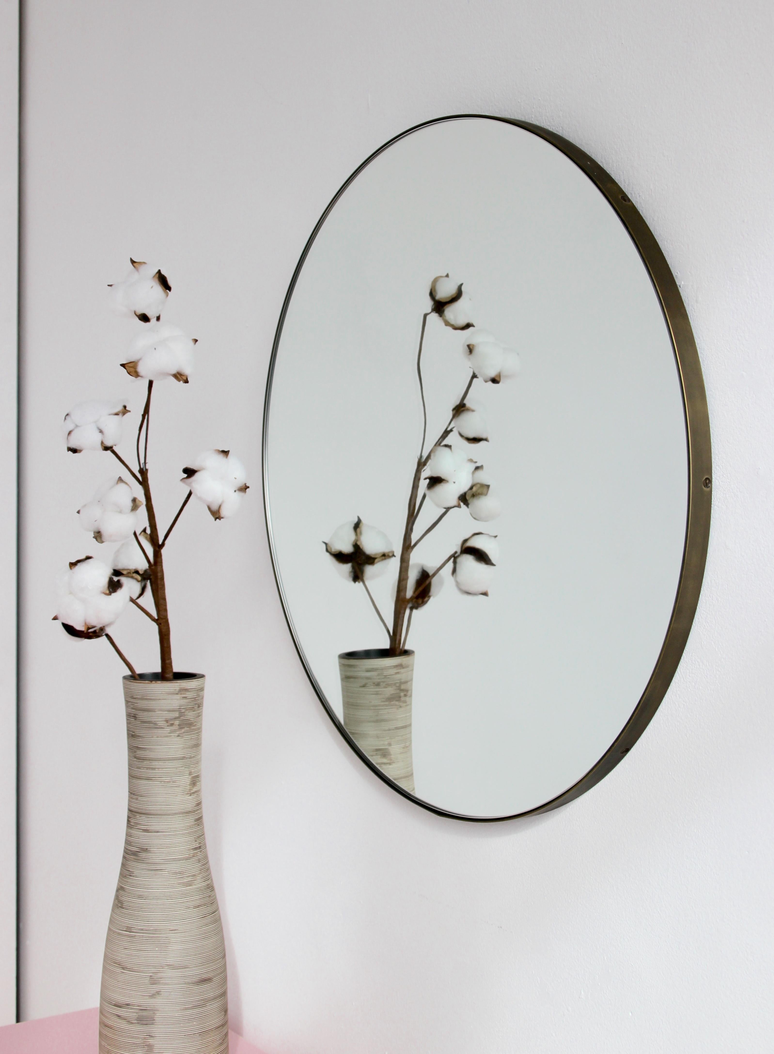 Minimalist Orbis™ round mirror with a solid brass frame with a bronze patina finish. Designed and handcrafted in London, UK.

The detailing and finish, including visible brass screws, emphasise the crafty and quality feel of the mirror, a true