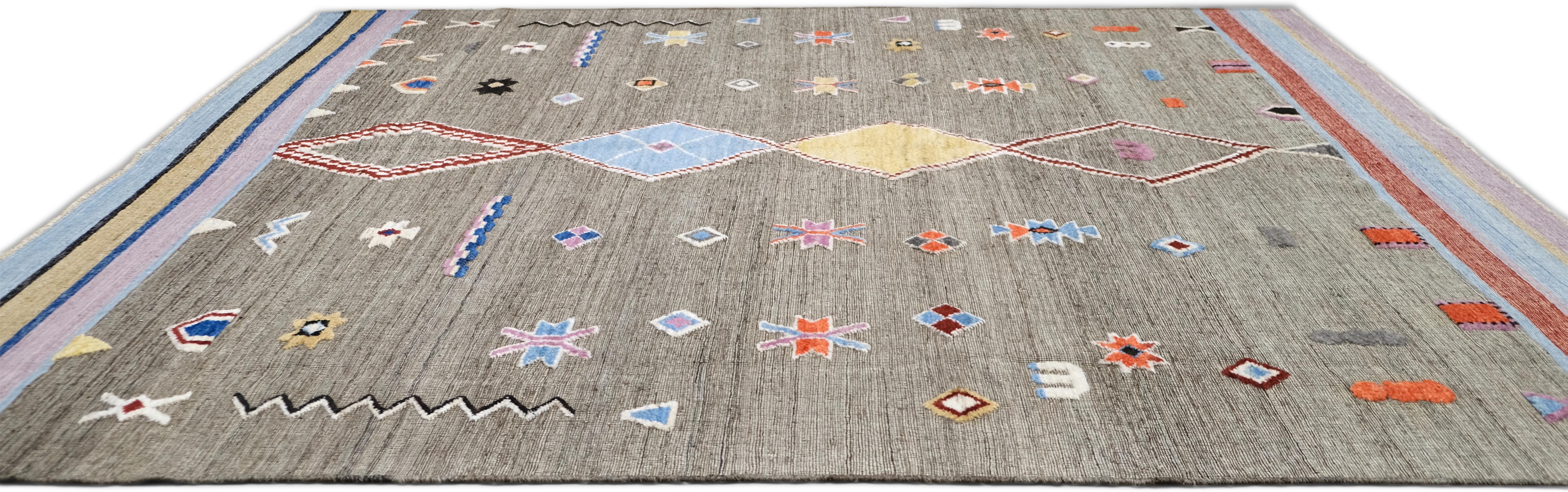 Infusez votre espace avec le charme vibrant de ce tapis en laine noué à la main. Avec son design géométrique tribal, cette pièce présente un mélange éclectique de formes audacieuses et de couleurs vives. La combinaison de motifs complexes et d'art