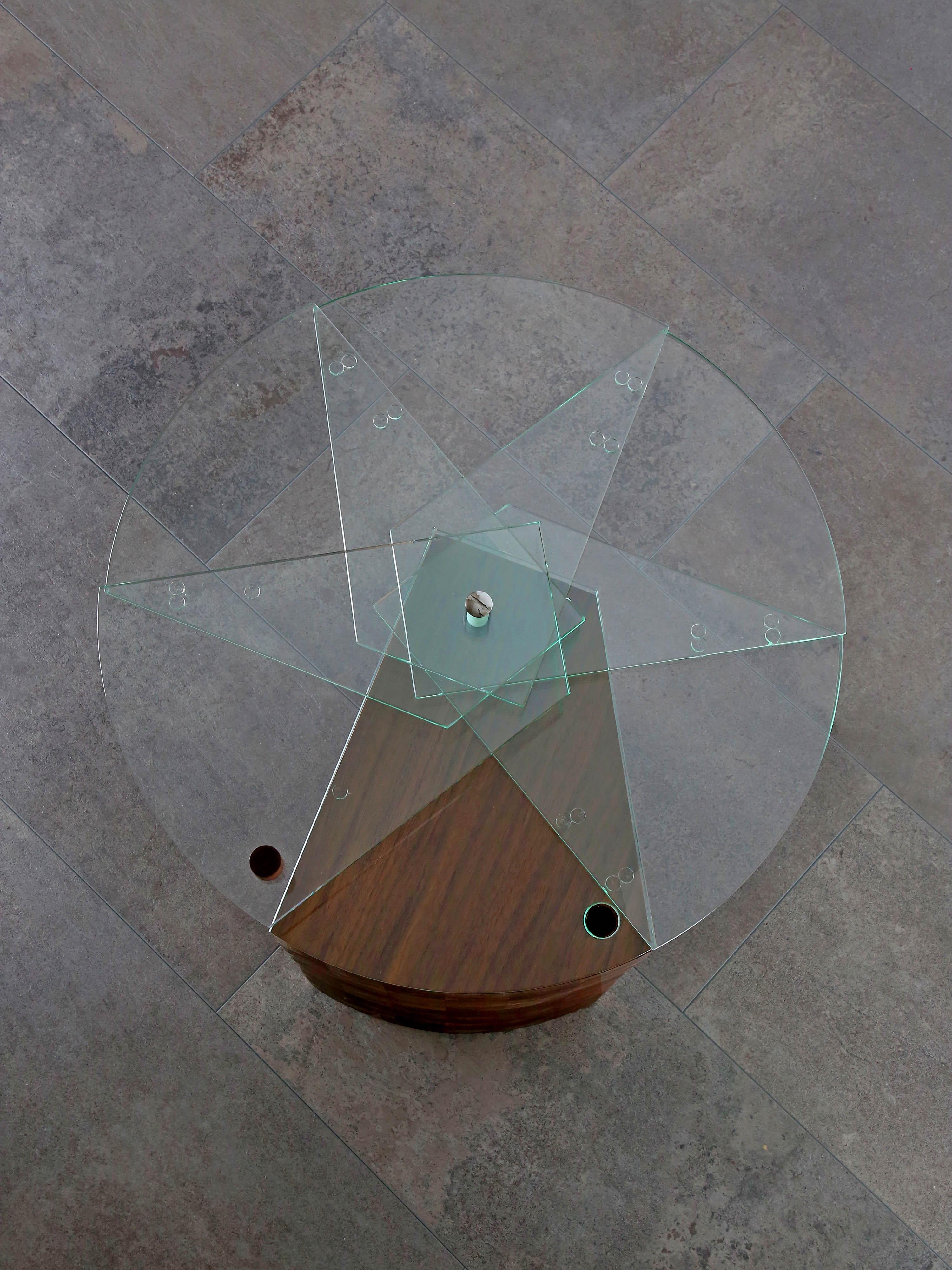 Side table RisingStar is made of solid walnut wood assembled into a pattern and glass cut into a special shape. An ingenious mechanism ensures the circular opening and closing of the table top.

The idea behind is to have not just a rigid table, but