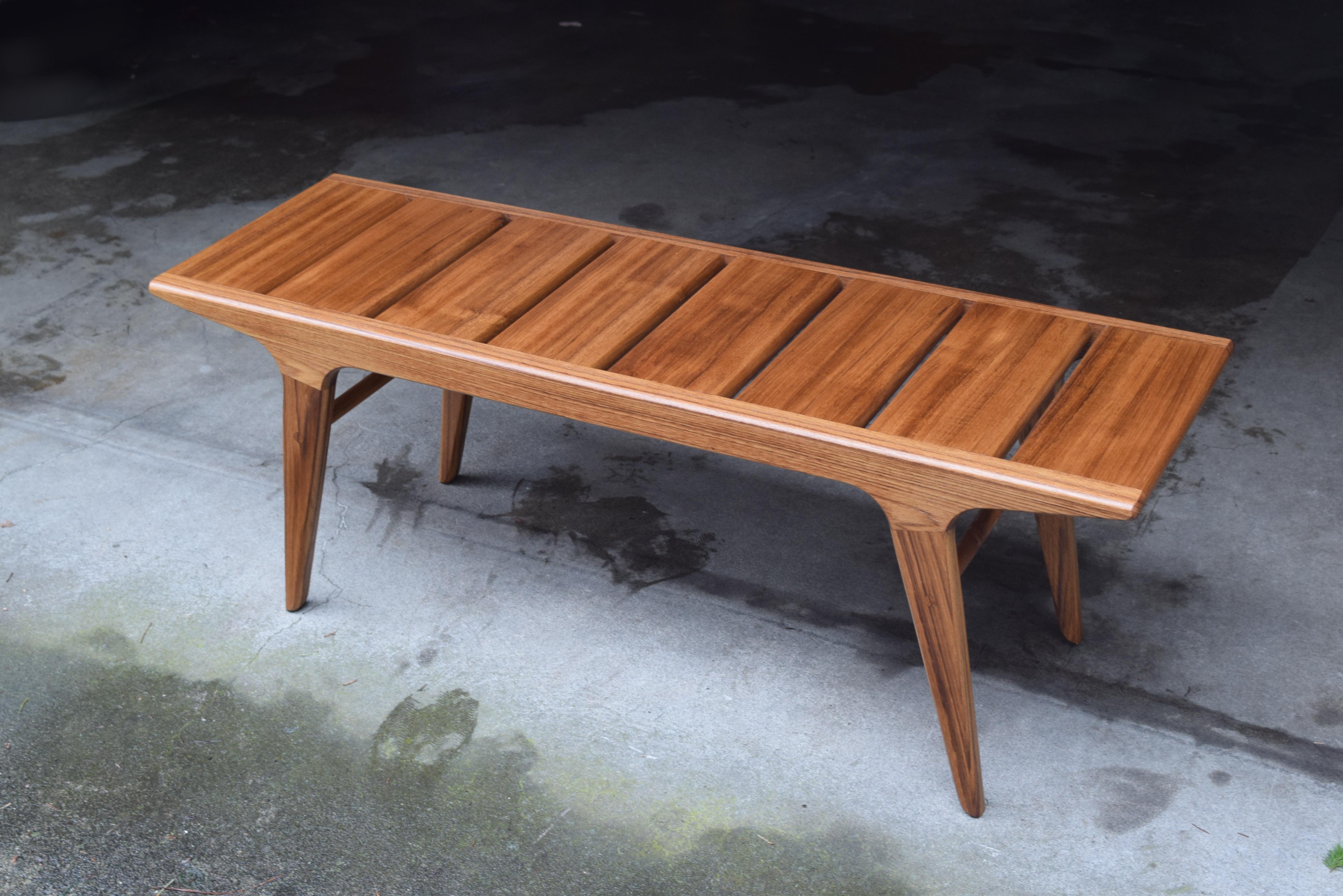 This bench represents the simplest kind of modern, with clean lines, elegantly tapered legs, and enduring hardwood construction. Shown here in teak with a hand rubbed oil and wax finish, the wood exhibits beautiful depth and color with subtle