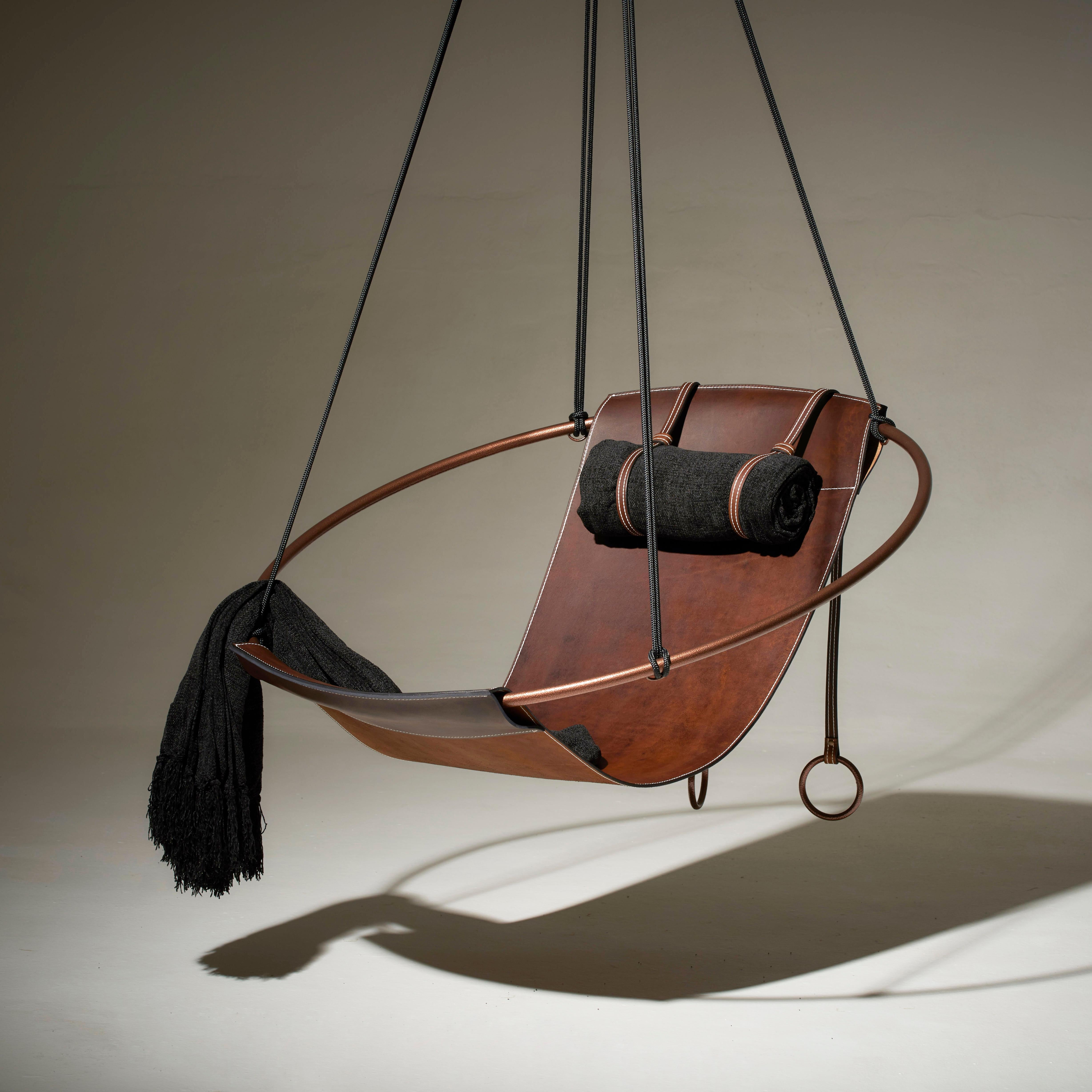 Dépouillé de tout superflu, ce fauteuil suspendu est doté d'un cadre circulaire et d'une feuille de cuir épais naturel suspendue à l'intérieur, pour créer une expérience élégante, sexy et très confortable. Les lignes épurées et la légèreté de cette