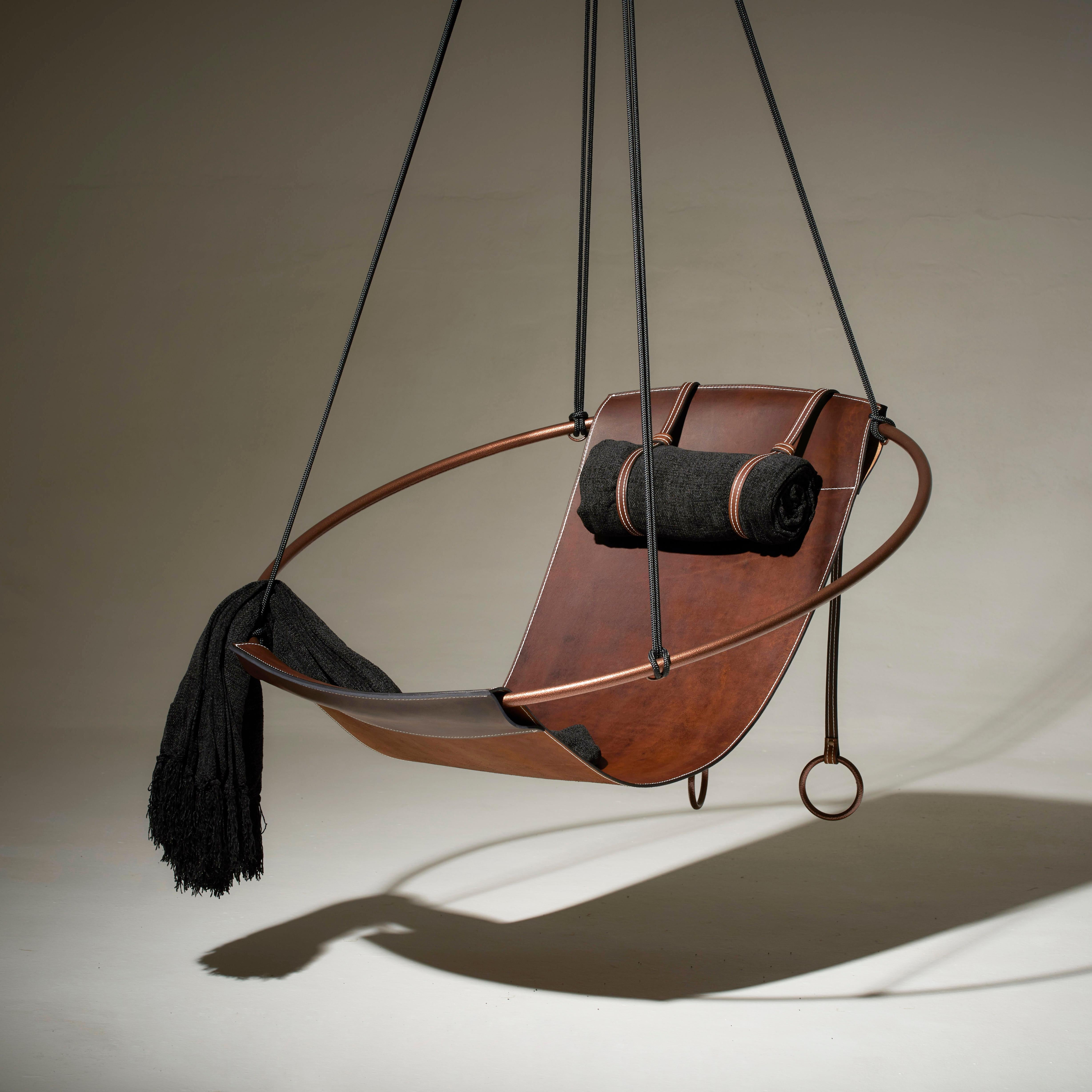 Stripped away from all excess, this hanging chair has a circular frame with a sheet of natural thick leather hanging loose within it, to create a sleek, sexy, and oh so comfortable experience. This chair’s clean lines and lightness makes it a