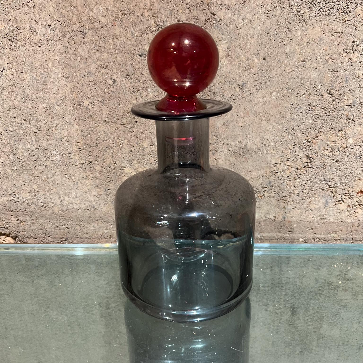 Modern Smoke Glass Decanter with Red Stopper
8.63 h x 4.75 diameter
Original unrestored vintage condition
Refer to images provided.