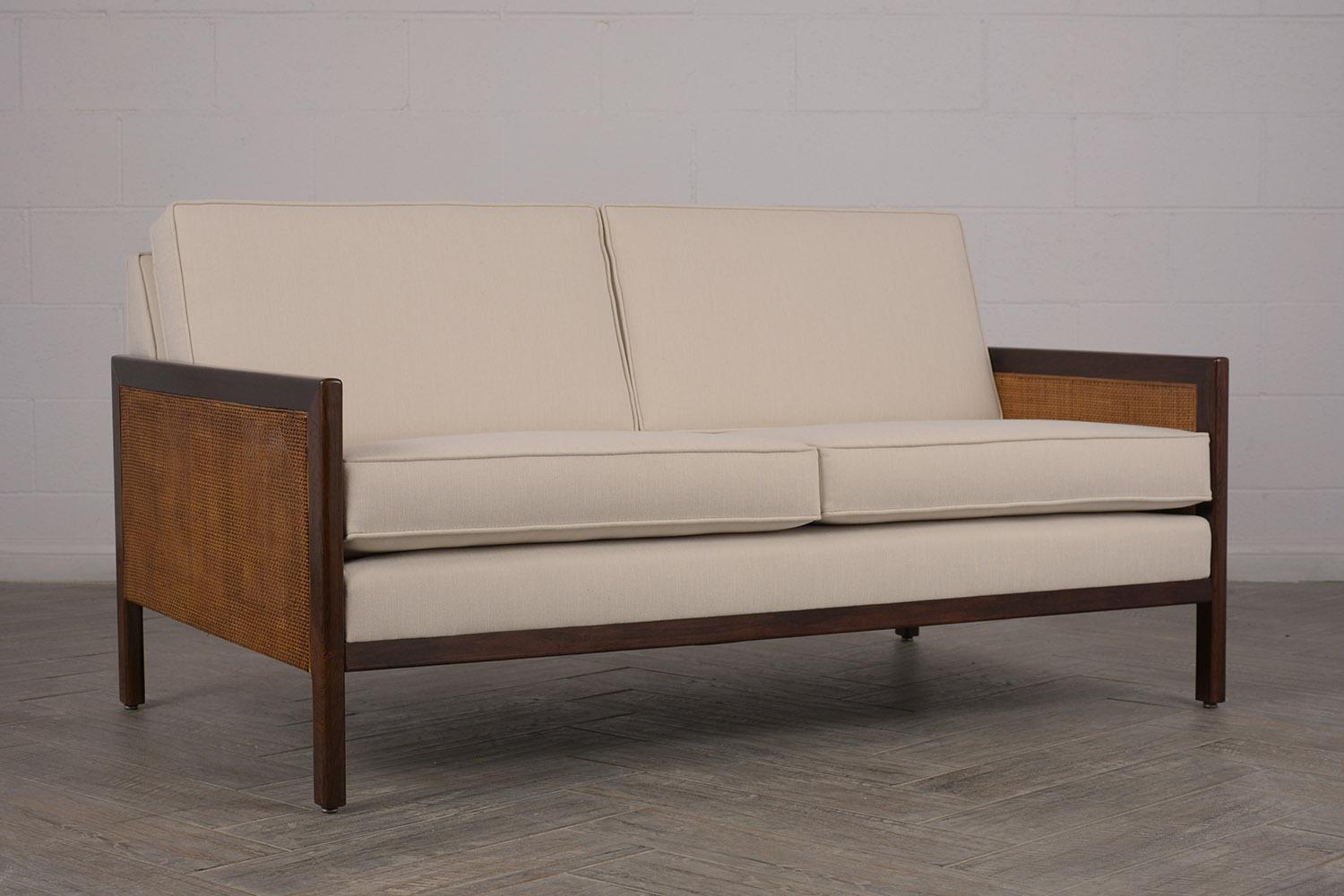 This is an elegant 2 person/cushion sofa Edward Wormley style. Has been fully restored to its original beauty and elegance. Frame is a rich solid rosewood, with double canning design, panels on both sides. Back, seat and cushions have been newly