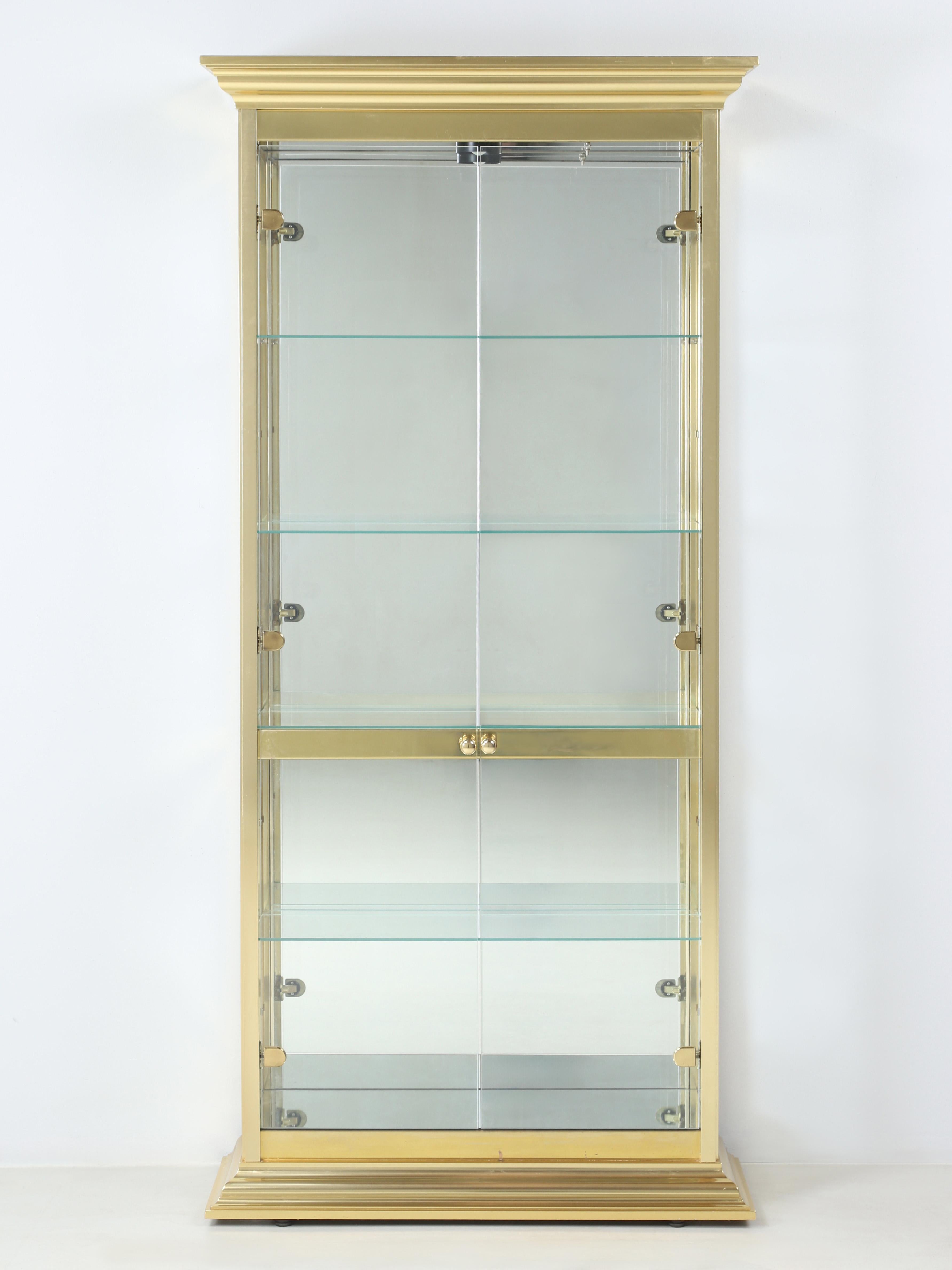 Modern Curio Cabinet that was made right here in America by the Glober Manufacturing Company of Carpentersville, Illinois. The Curio-Cabinet was constructed from solid brass and glass with a mirror back and floor panel and above lighting. The glass
