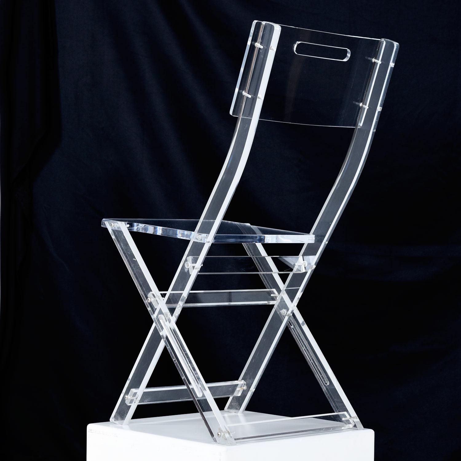 Pair of mysterious Lucite acrylic folding chairs in exceptional condition. We've never seen anything like these before and had no luck coming up with a definitive manufacturer or designer. The typical style folding chair is never entirely Lucite.