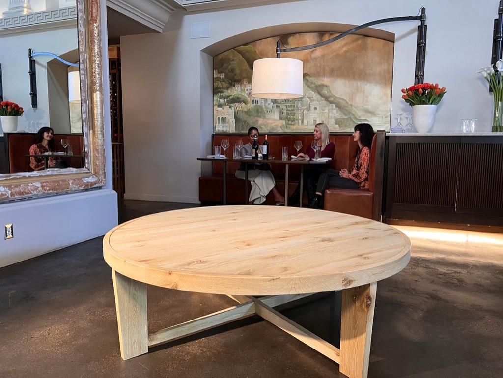 La grande table centrale ronde Alastair est fabriquée à la main avec du chêne blanc américain massif vieux de 100 ans. Fabriquée à partir de chêne recyclé, chaque pièce, tout en portant des marques distinctives, partage un style intemporel de vieux