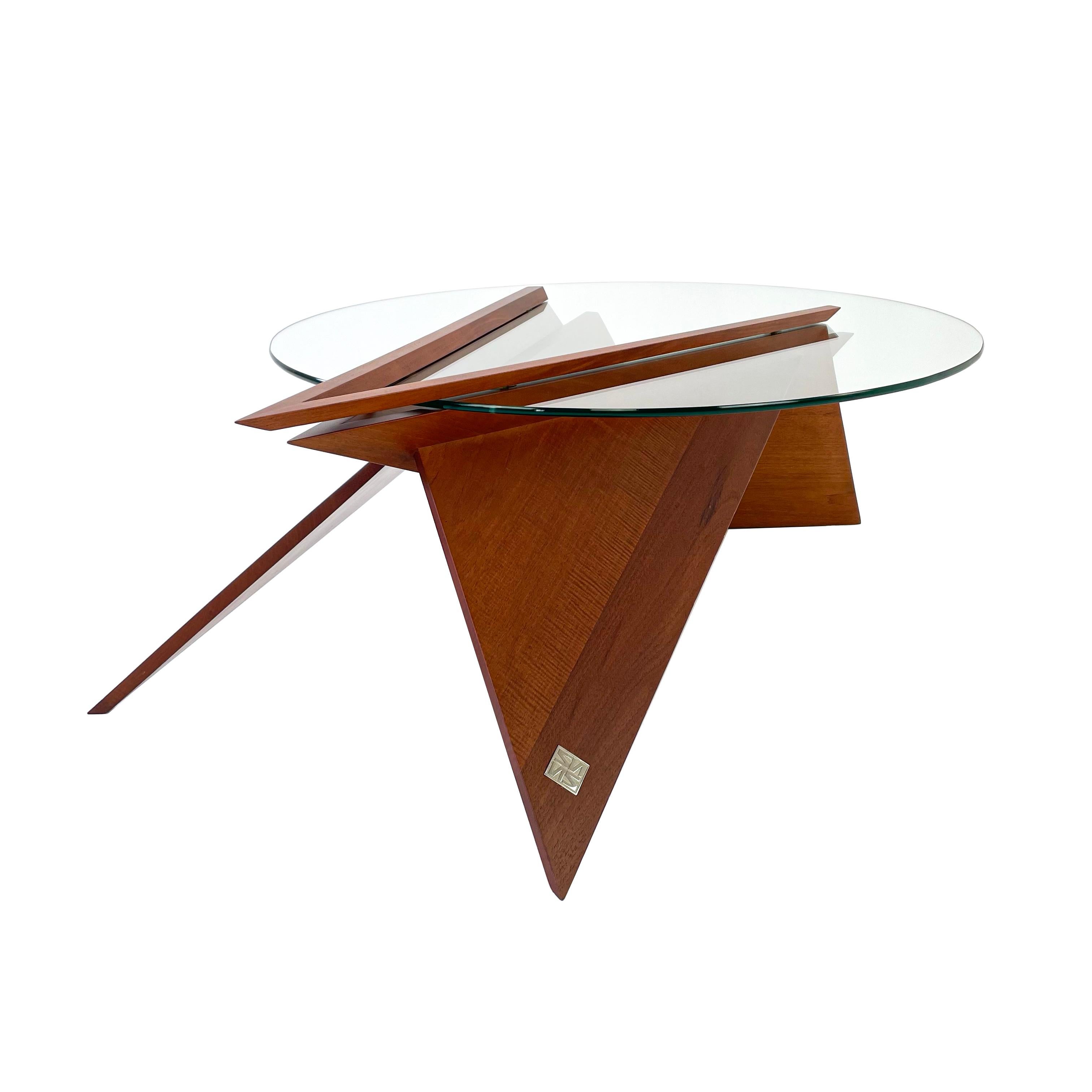 Modern solid wood and glass cocktail table by Pierre Sarkis from Valentina Collection. Inspired in the Origami Folds theory, finding in basic geometry meaning of life, truth and beauty. Stunning coffee table with thick round clear glass top.