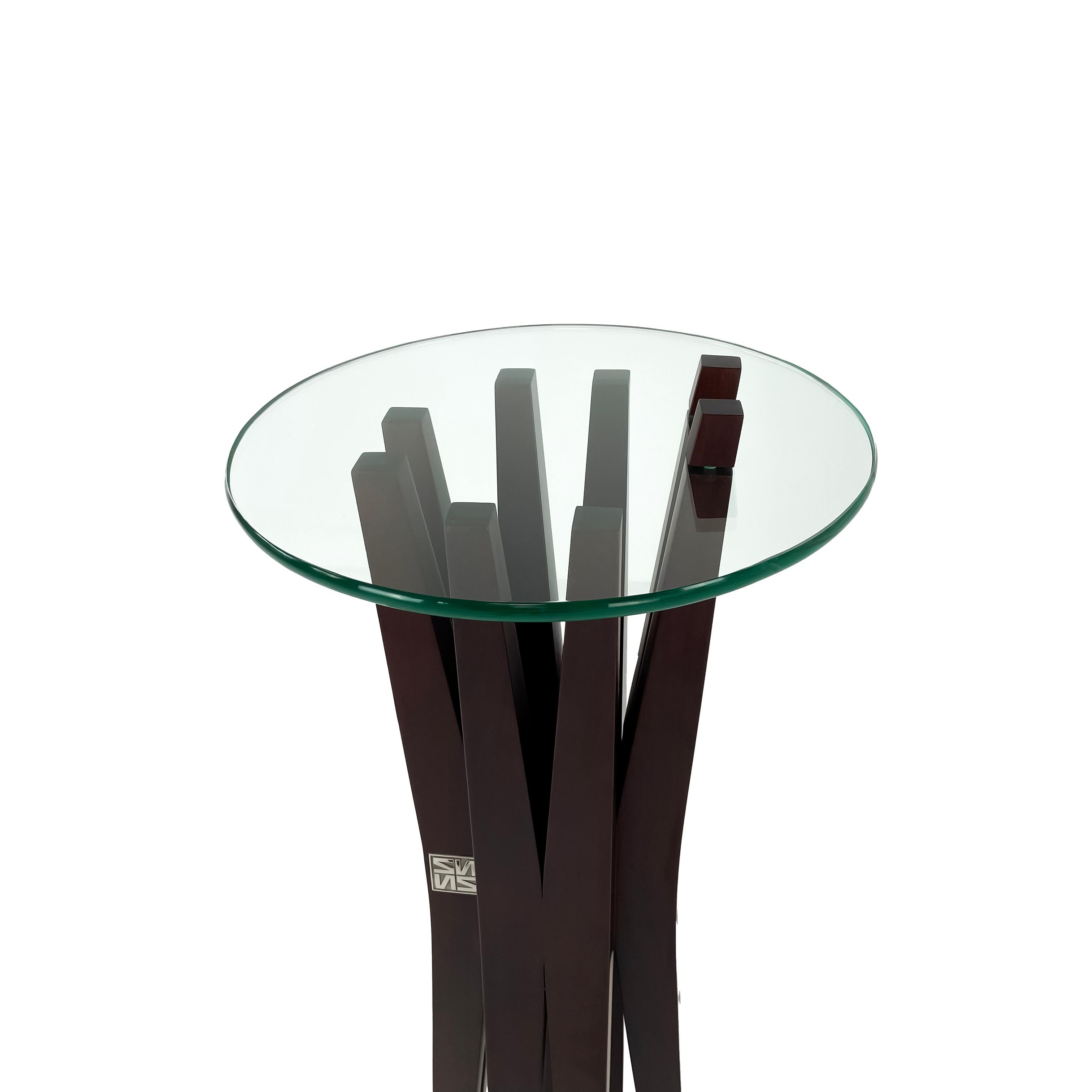 Modern solid wood and glass pedestal by Pierre Sarkis from Celine Collection. Inspired by the roots and branches of a tree that represents life and beauty. Elegant pedestal with tempered glass top.
Dimensions: Glass top: 0.5