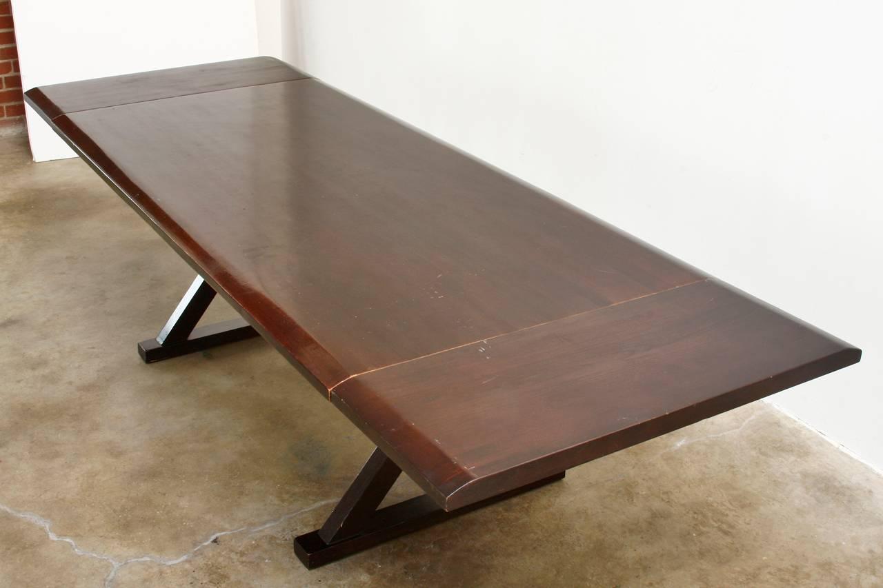 Modern trestle dining table constructed from thick solid wood. Features an x-form base and a simple Minimalist style design. The top is made of nearly 2
