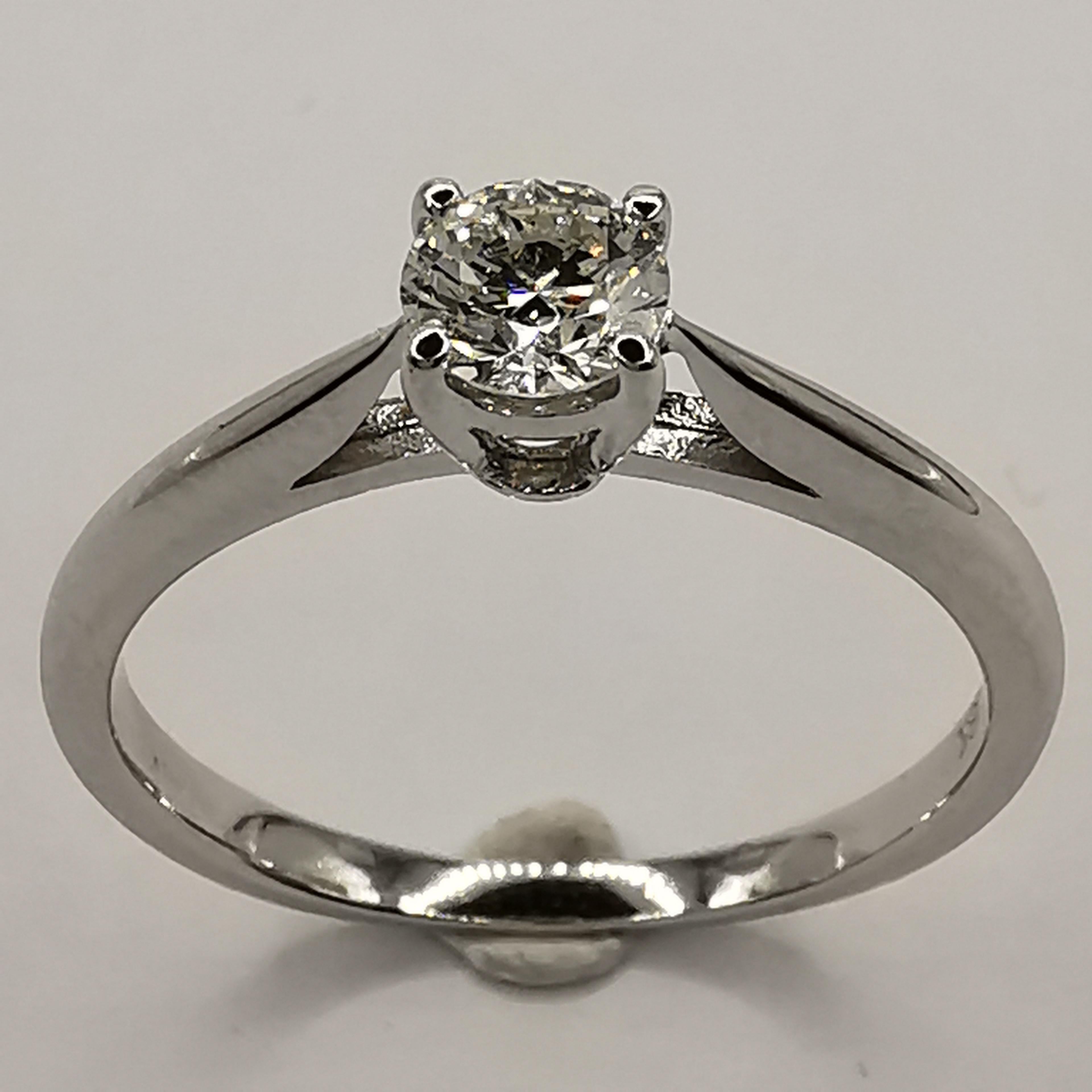 Cette bague de fiançailles en diamant solitaire, élégante et moderne, est le choix idéal pour tous ceux qui recherchent une pièce intemporelle et stylée. La bague est fabriquée en or blanc 18 carats de haute qualité et présente un sertissage