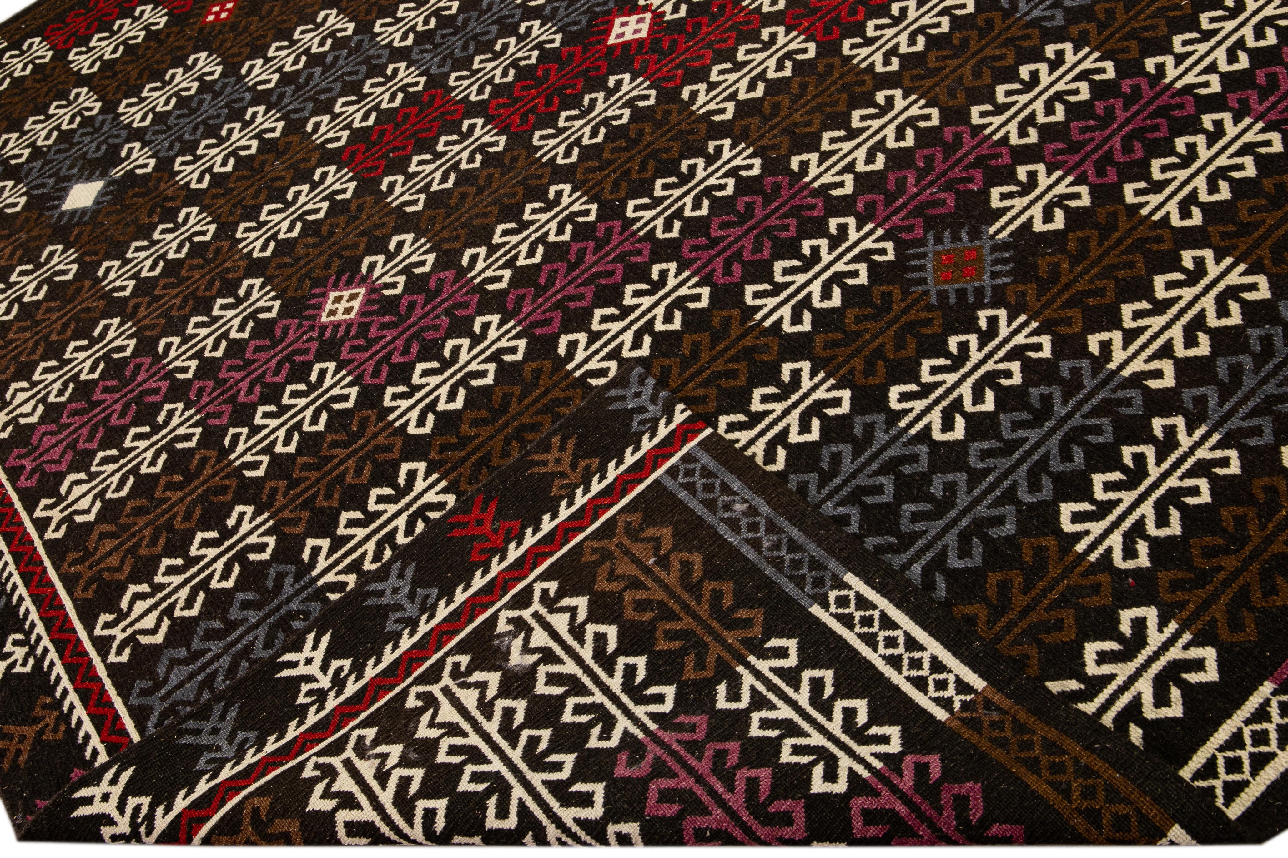 Beautiful Modern Soumak hand-knotted wool rug with a dark brown field. This piece has multicolor accents in a gorgeous all-over geometric design.

This rug measures: 10' x 14'.

Our rugs are professional cleaning before shipping.