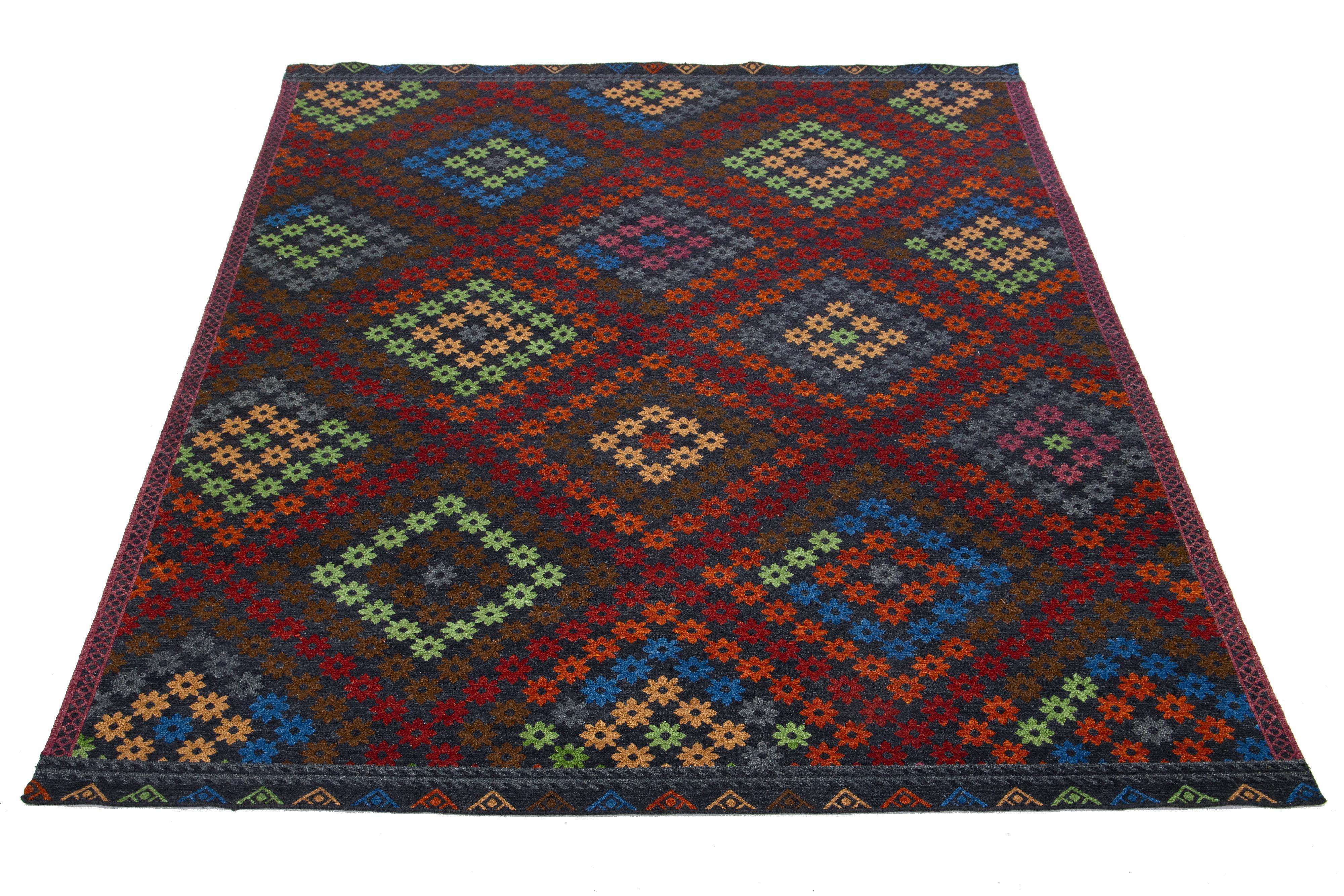 Il s'agit d'un magnifique tapis moderne en laine Soumak nouée à la main avec un champ gris foncé. Il présente des accents multicolores dans un magnifique motif géométrique.

Ce tapis mesure : 9'2