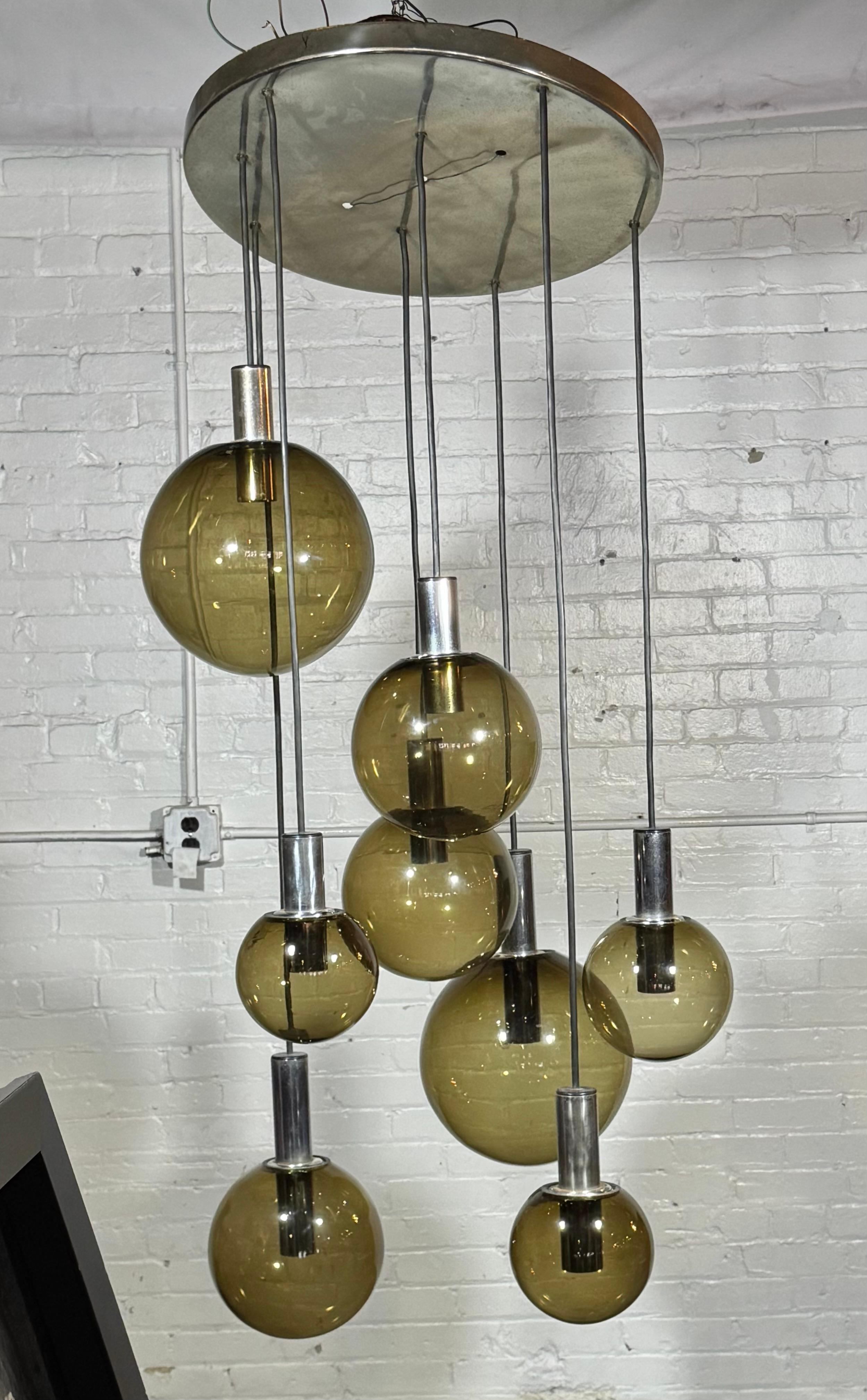 Ce ravissant lustre est fabriqué par le fabricant néerlandais de lampes du milieu du siècle par excellence RAAK Amsterdam. Il a été baptisé cascade maxi-globe. Cette pièce impressionnante est composée de pas moins de huit pendentifs en verre soufflé