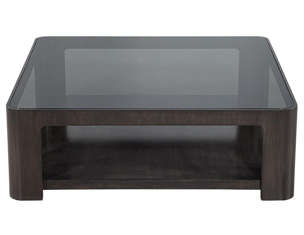 Modern Square Coffee Table with Smoked Glass by Baker Furniture. Original design by Baker Furniture, finished in a dark rustic satin finish. Completed with smoked glass top. Features beautifully curved corners and 2 tier design with lower shelf