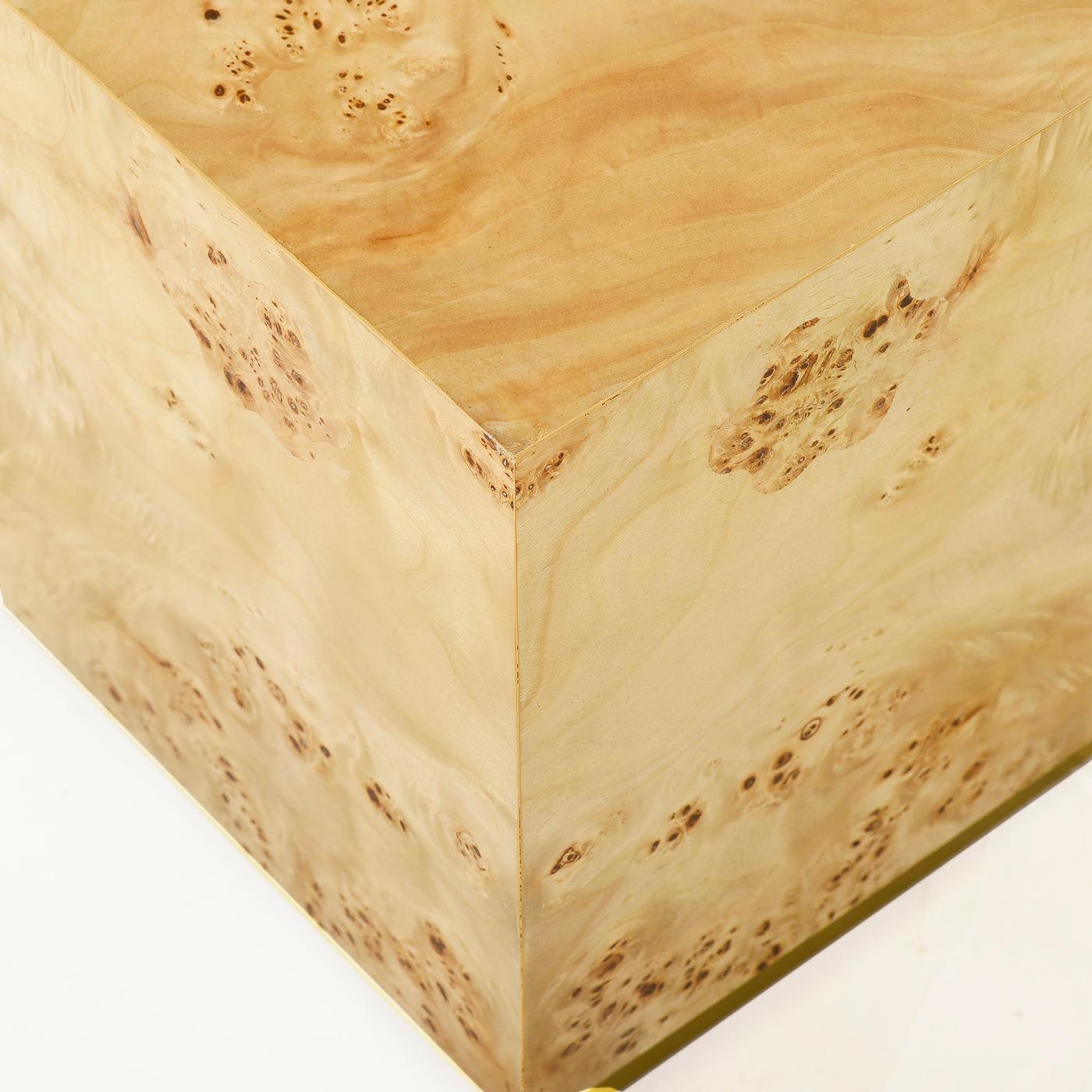 Featuring richly textured clear polished burl veneer with a medium polished finish that highlights its naturally occurring swirls and patterns. The striking cube-shaped design celebrates clean geometric lines, while the sleek brass plinth base