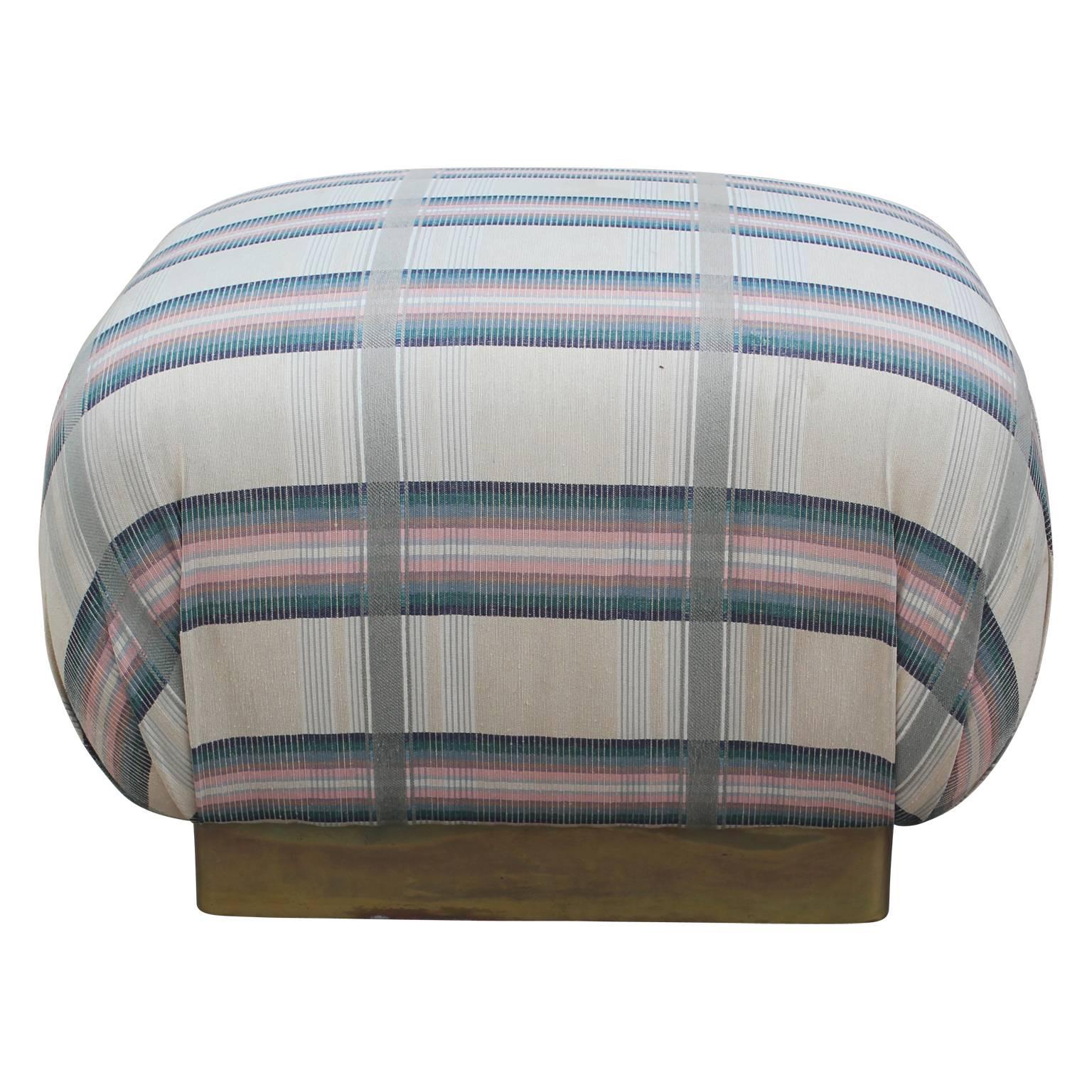 Unique square ottoman pouf in the style of Karl Springer with a brass base.  Currently upholstered in it's original fabric but if you'd like different fabric you can do a COM and we can upholster it. 