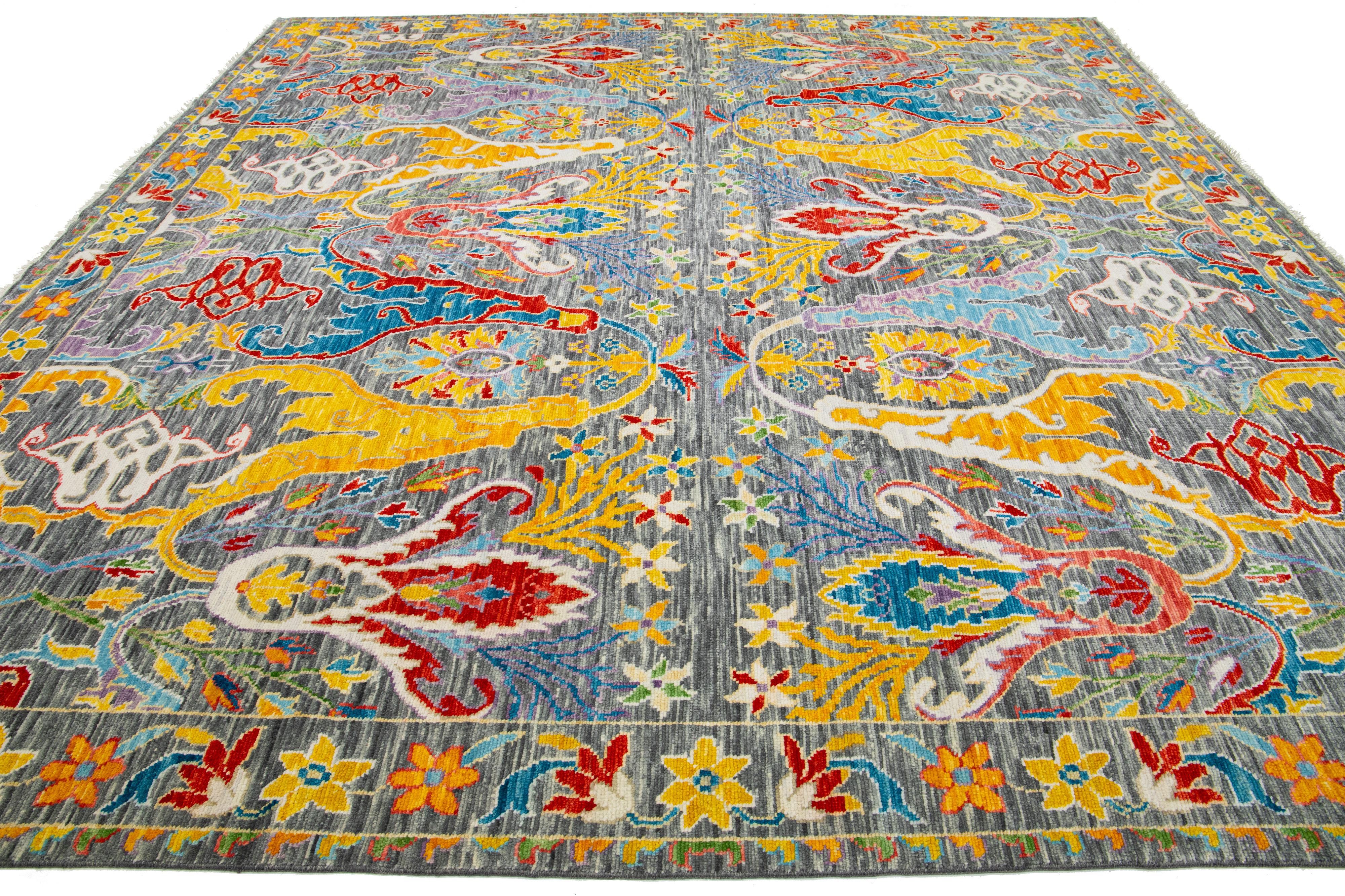 This square wool rug in Oushak style showcases a hand-knotted gray background, exuding a modern aesthetic with its vibrant, multicolored floral design spread throughout.

This rug measures 11'9