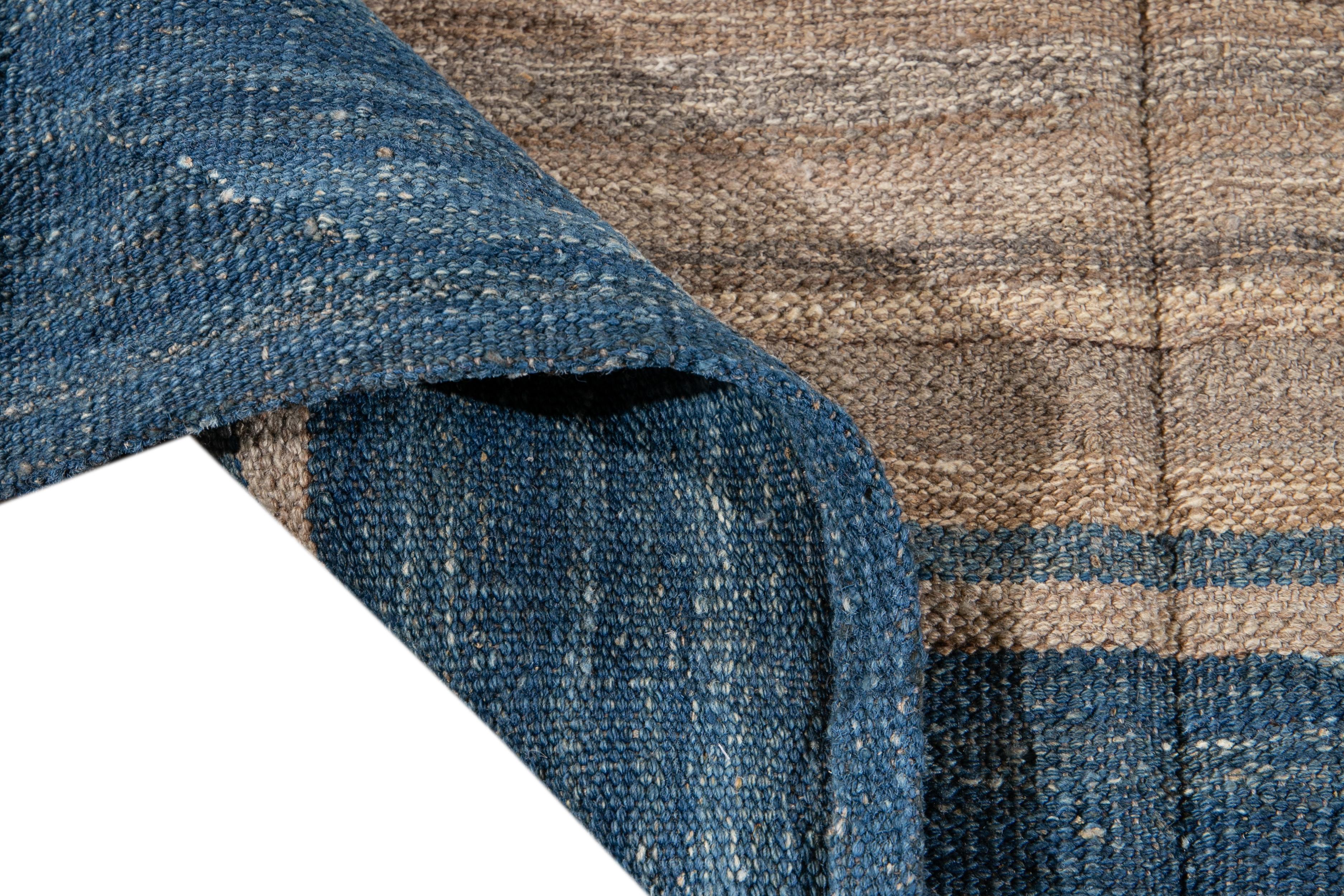 Schöner moderner flachgewebter Kilim-Teppich aus handgeknüpfter Wolle. Dieser Teppich hat ein Feld aus blauen und beigen Farben in einem wunderschönen geometrischen Streifendesign.

Dieser Teppich misst: 6'10