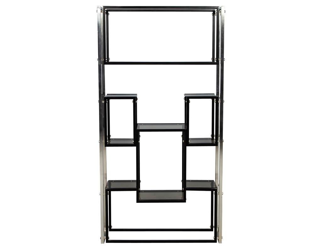 Modern stainless steel smoked glass étagère. Mid-Century Modern piece from the USA, manufactured in the 1970s. Featuring polished stainless steel frame with black painted details and smoked glass shelves.
Price includes complimentary curb side