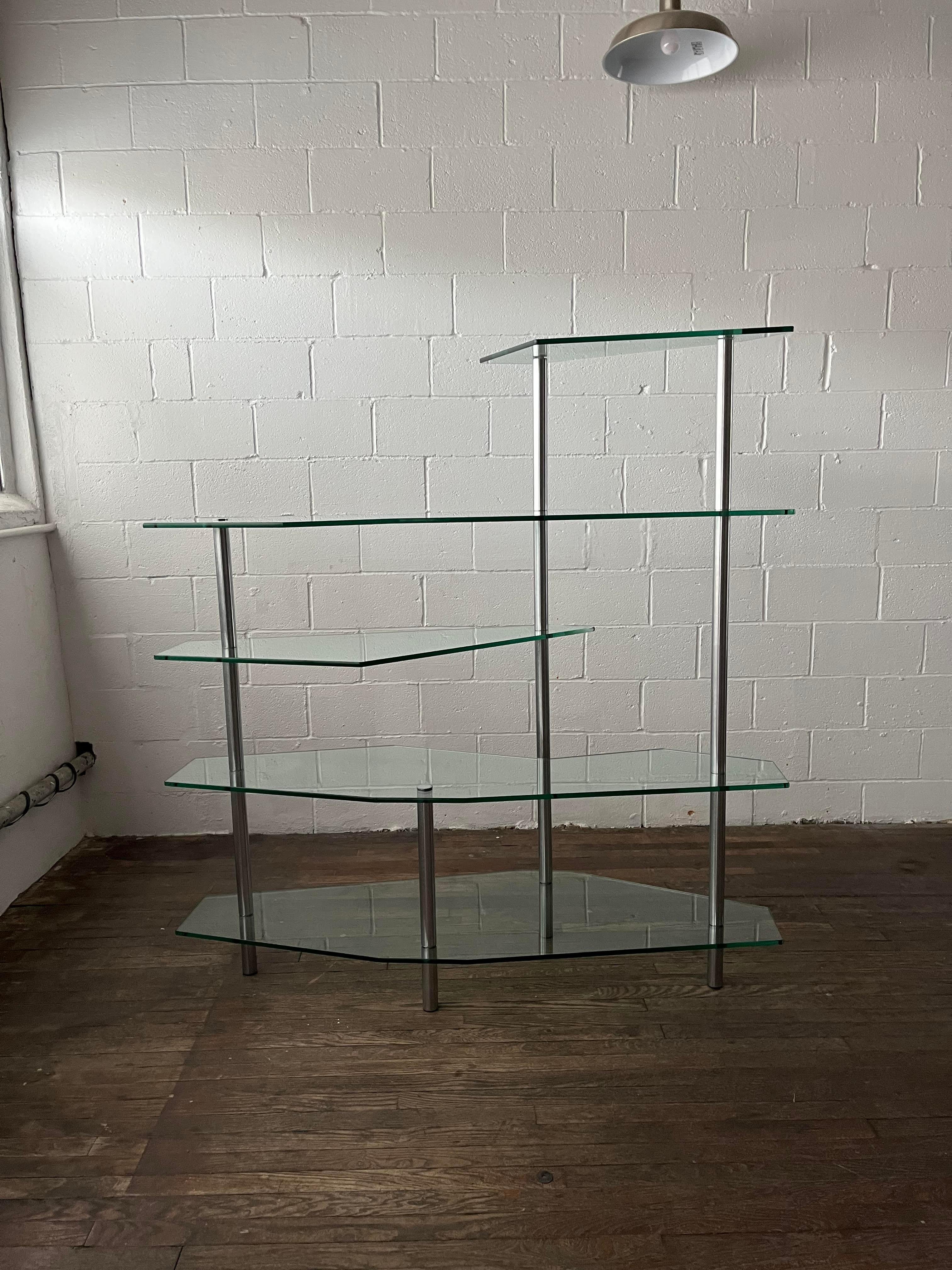 A modern yet elegant steel and glass etagere. Brushed steel frame hols unique freeform glass shelves to create a sophisticated and modern look. Thick glass shelves in varying shapes to keep the eye moving.
Will be dismantled for shipping. 

Curbside
