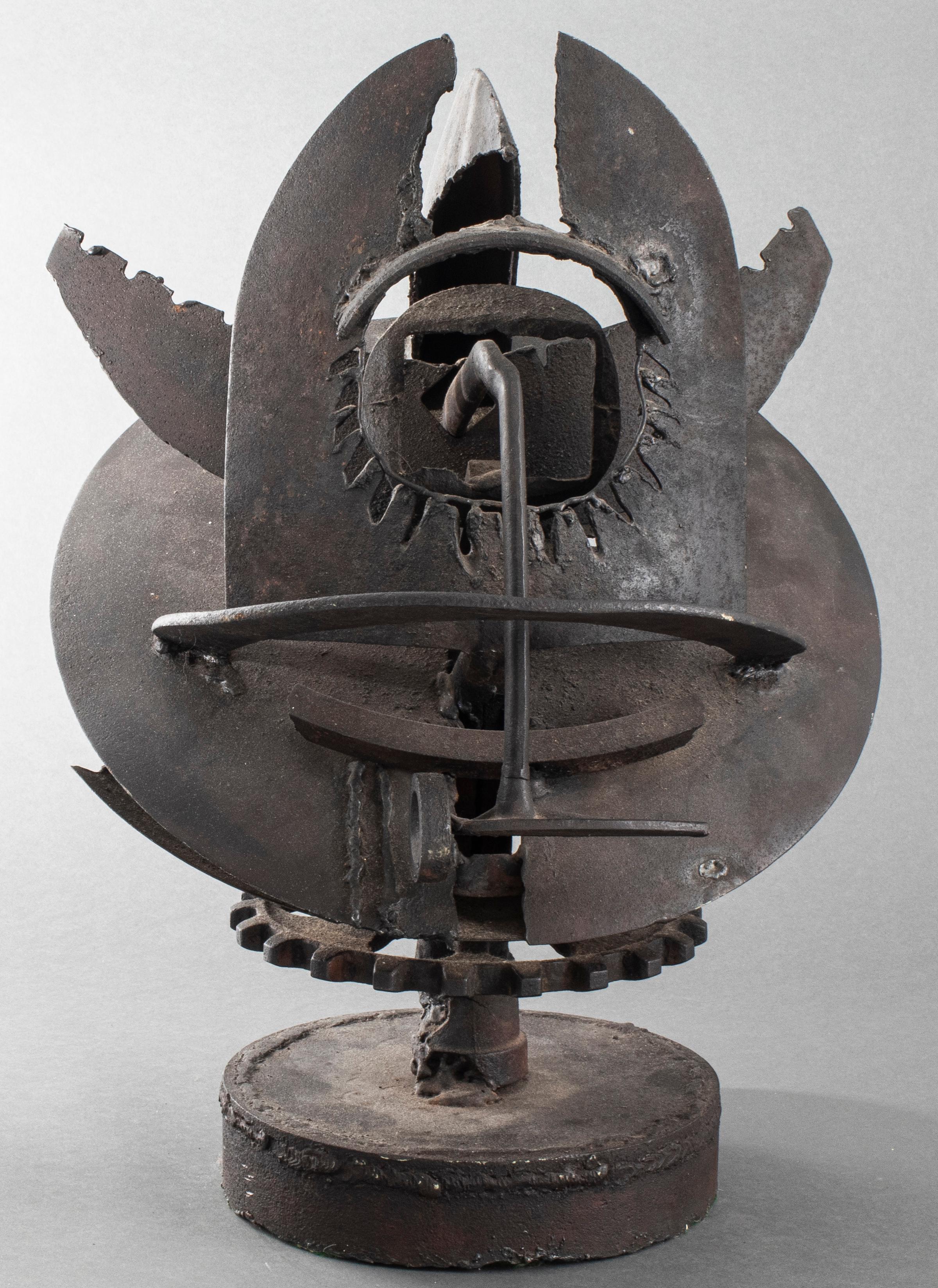 Modern steel and iron sculpture with various elements including a hammer, shovel, and hoes on round base. Measures: 20.5” height x 16.5” diameter.