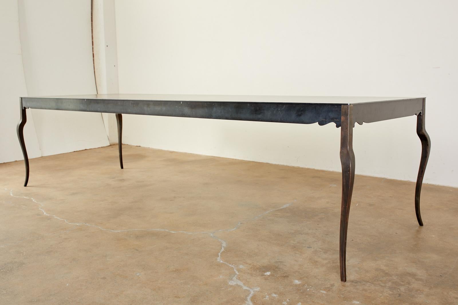 Magnificent modern style handcrafted steel dining table by Gregor Jenkin Studio Cape Town, South Africa. Features a 9.5' foot rectangular top supported by elegant, tapered cabriole legs. The massive table is substantial yet has an impossibly thin