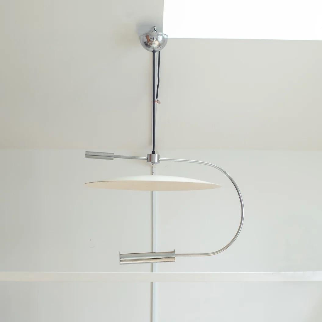 This pendant light was produced by Maison Lucien Gau, a French manufacturer founded in 1860. It is a rare type of lighting that reflects light from the socket at the bottom onto a circular shade.