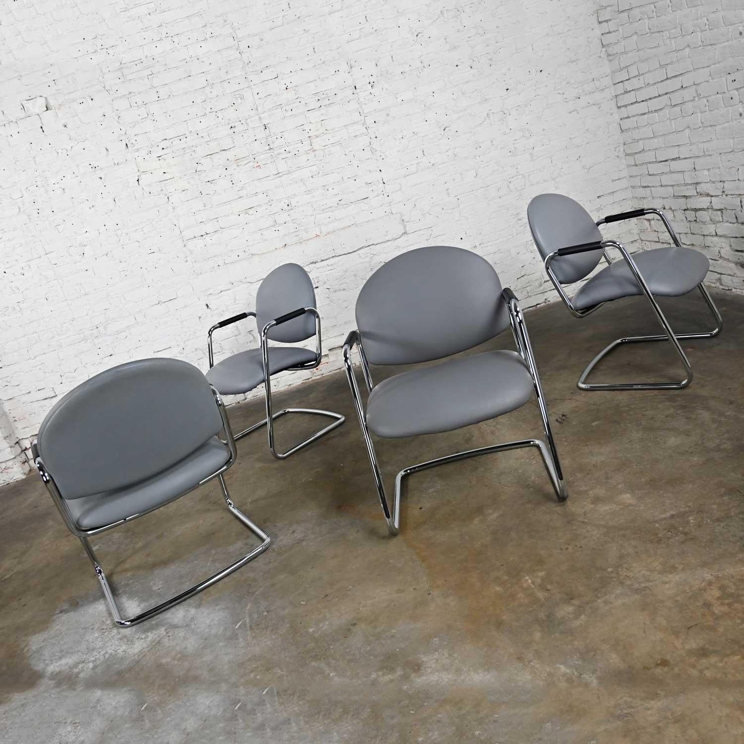 Handsome vintage modern Steelcase chrome tube cantilever base original gray faux leather or vinyl seats and rounded backs, set of 4. Beautiful condition, keeping in mind that these are vintage and not new so will have signs of use and wear. Small