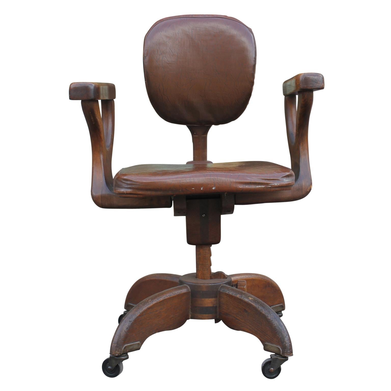 Craftsman style office chair with entirely wooden adjustable mechanisms. Seat area covered in Naugahyde material. Chair is on a set of 4 rollers.