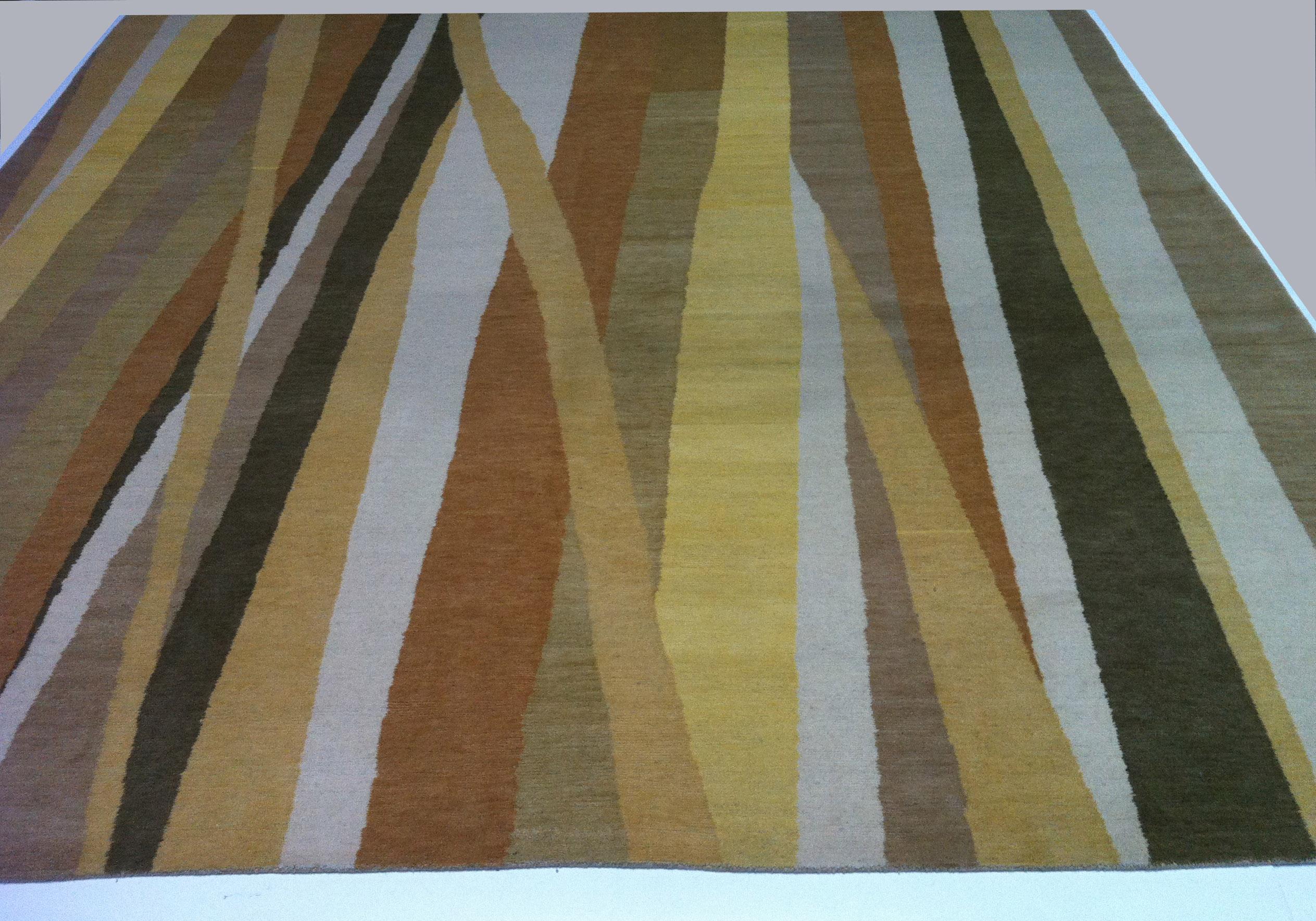 Warm earthy colors and a modern take on stripes come together to create a rug that would be equally at home hanging on the wall as a piece of modern art. A great piece to complement a palette of natural finishes and textures. Tones include gold,