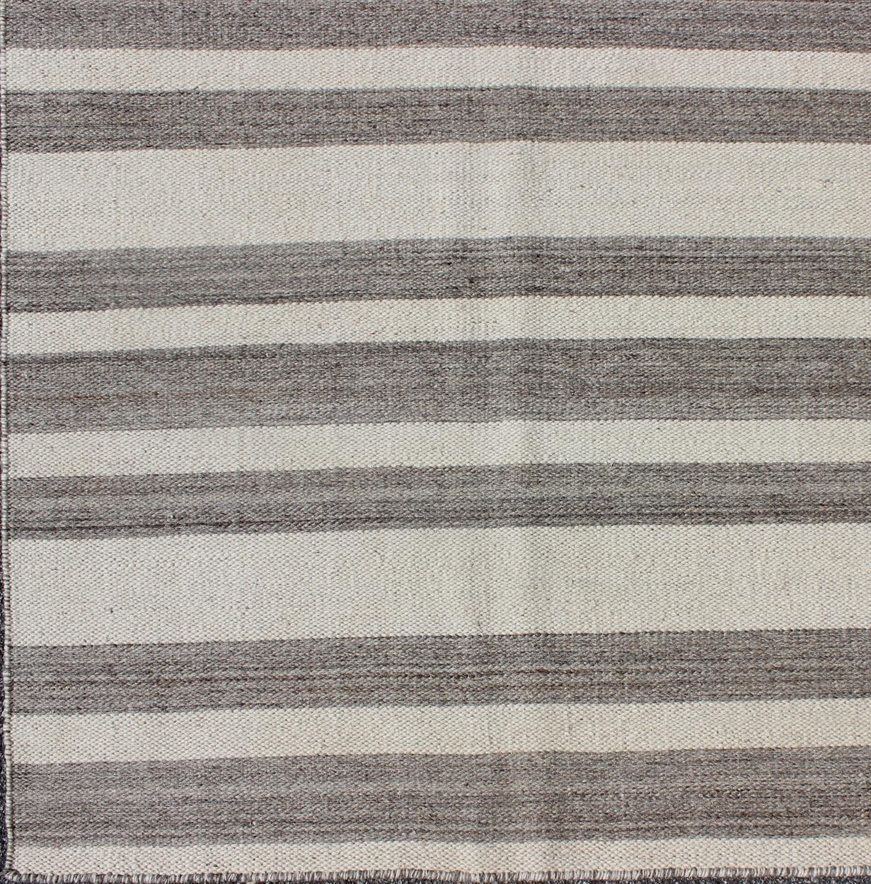 Casual flat-weave Kilim rug with gray and cream in Classic Stripe design, rug BDH-113556 country of origin / type: Afghanistan / Kilim

This vibrant Kilim rug features a Classic stripe design, perfectly suited for casual and easy interiors, such