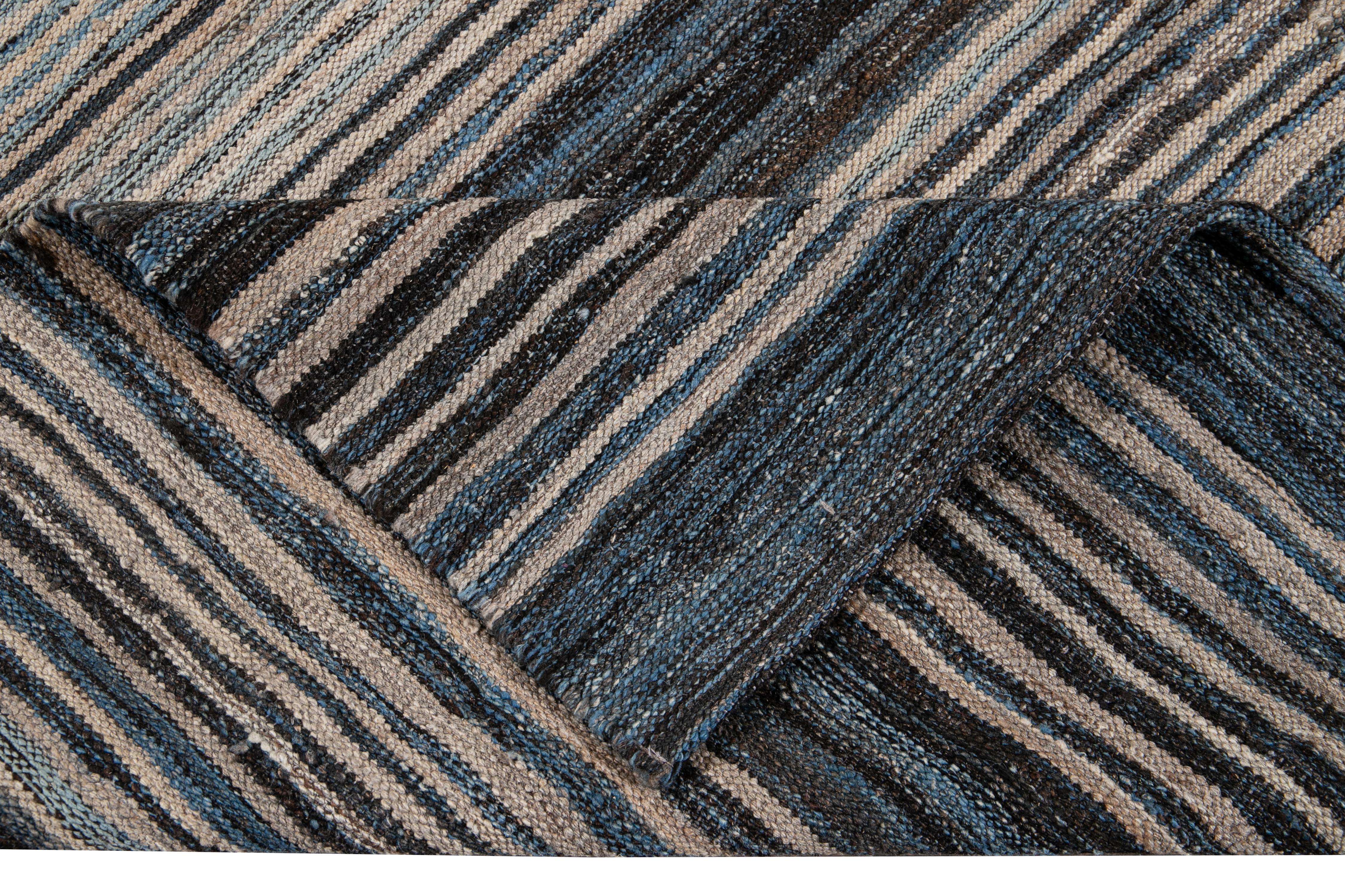 Beautiful Modern flat-weave handmade wool rug. This Kilim rug has a beige field with accents of blue and brown in a gorgeous geometric striped design.

This rug measures: 9'4