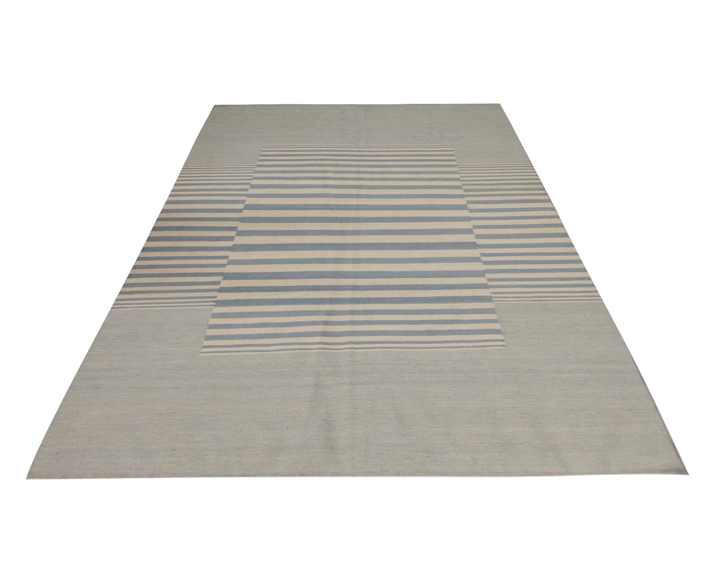 This modern flatwoven kilim is a handwoven piece constructed in Afghanistan. The design is woven with a bold stripe pattern with a simple blue and cream Scandinavian colour palette. This fine wool kilim is simple yet elegant, enhancing modern and