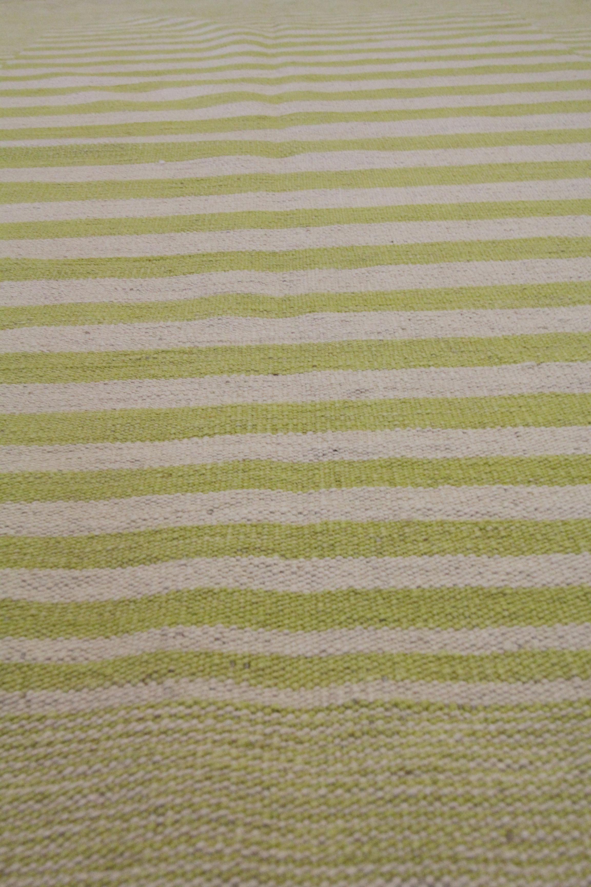 This modern flatwoven Kilim is a handwoven piece constructed in Afghanistan. The design is woven with a bold stripe pattern with a simple mustard yellow and cream colour palette. This Fine wool Kilim is simple yet elegant and enhances both modern