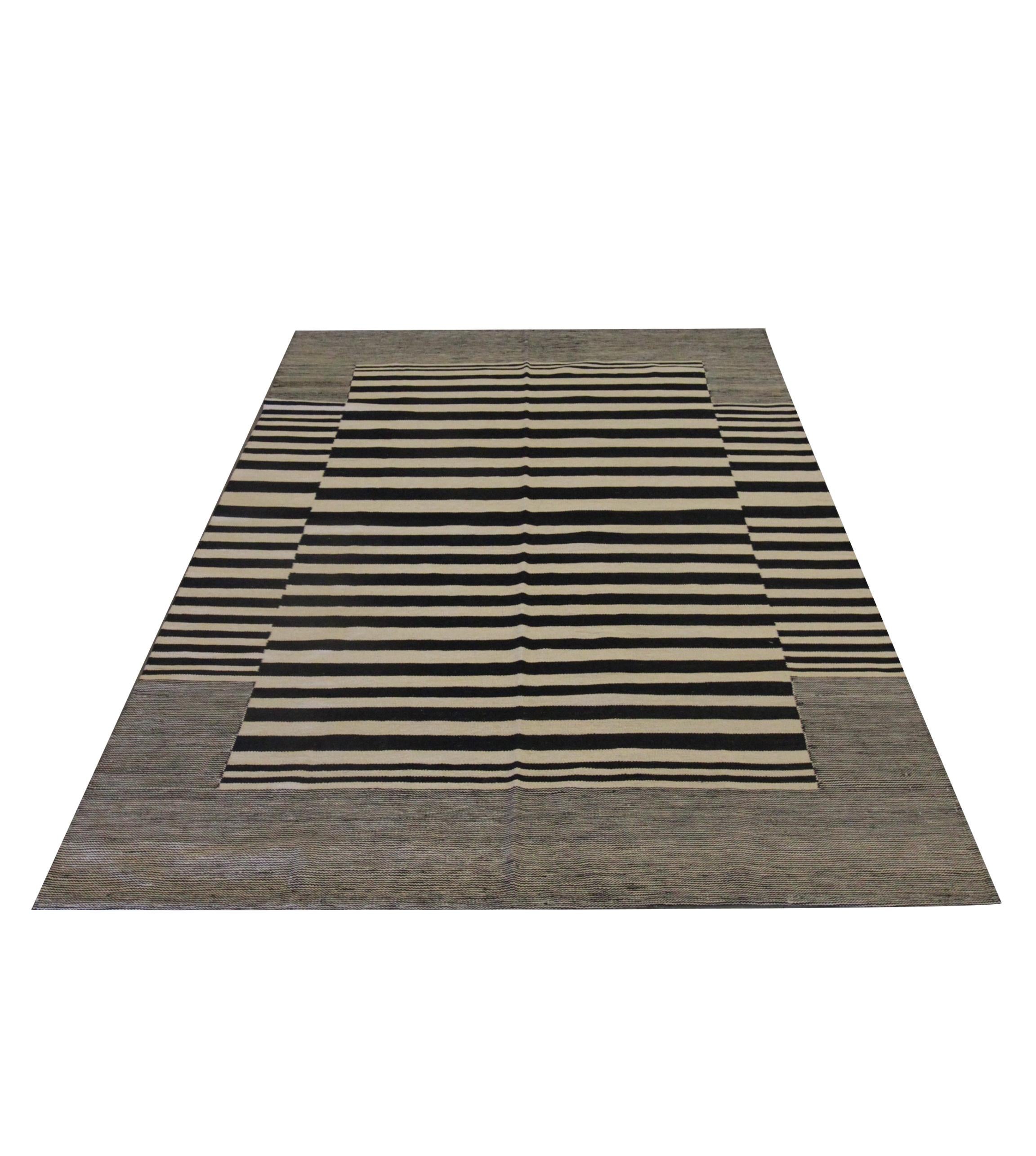 This modern flatwoven kilim is a handwoven piece constructed in Afghanistan. The stylish striped rug design has been woven with a bold stripe pattern with a simple black and cream colour palette. This fine wool kilim is simple yet elegant and sure