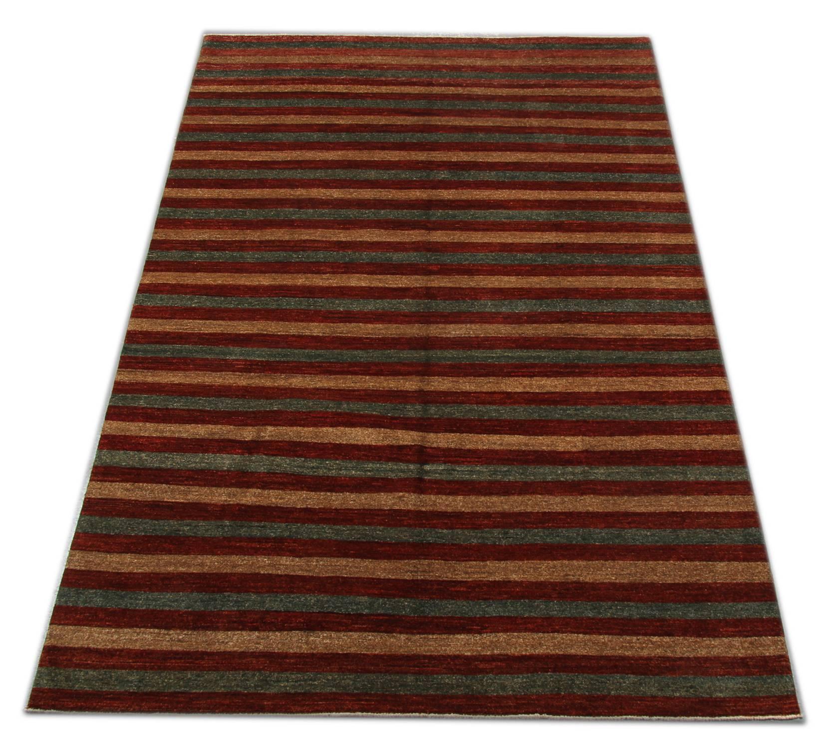 Oriental rug with rich colors and abstract elements, this modern woven rug gives a subtle contemporary appearance. Featuring a beautiful palette of gold green and red colors, this striped rug is grounded in stylish colors that will add a touch of
