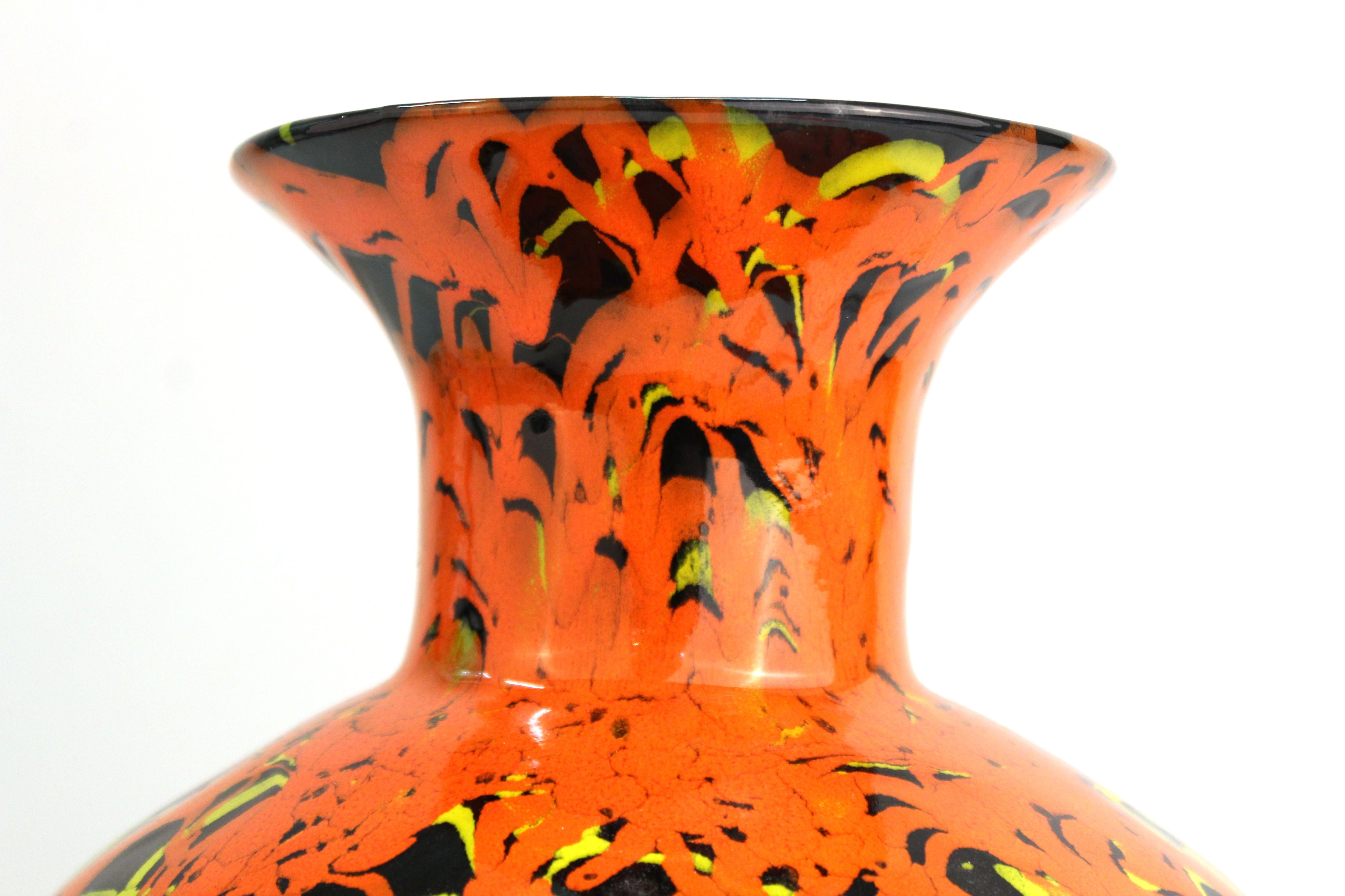 Modern studio art pottery vase in baluster shape. The piece has orange and red drip glaze on the upper part, on a black base. In great vintage condition with age-appropriate wear and use.