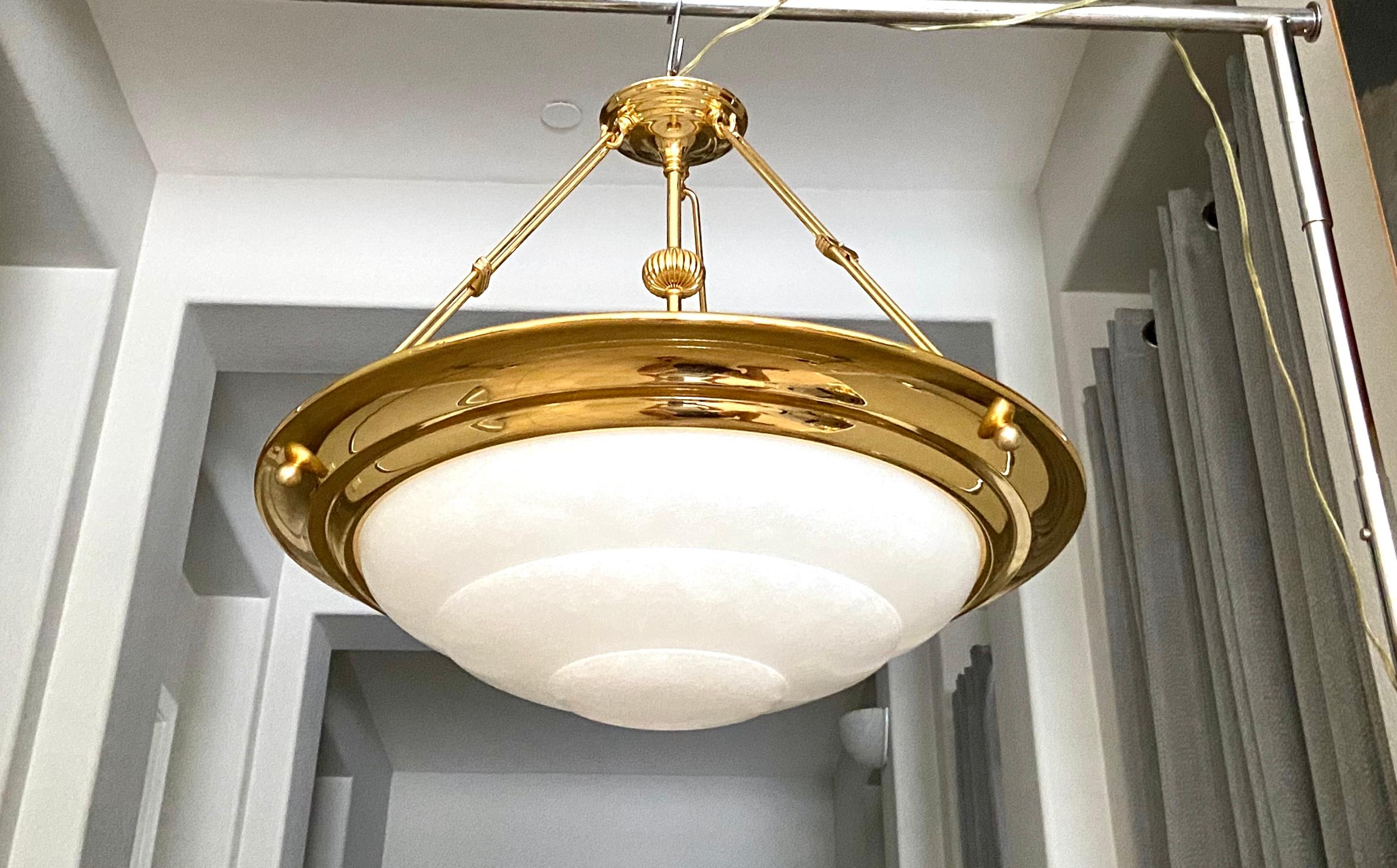 Sleek larger scale carved alabaster chandelier with 3-light and brass finish hardware fittings, perfect for both modern and tradition taste. The polished brass plating is designed with clean lines accented with simple yet elegant detailing, and is