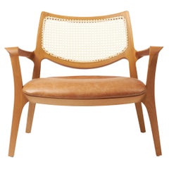 Modern Style Aurora armchair Sculpted in solid wood, caning back, leather seat