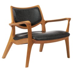 Fauteuil Aurora de style moderne sculpté en bois massif, assise et dossier en cuir