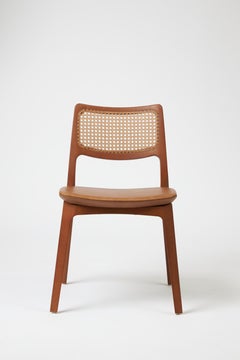 Sedia Aurora in stile moderno scolpita in finitura noce senza braccioli, seduta in pelle