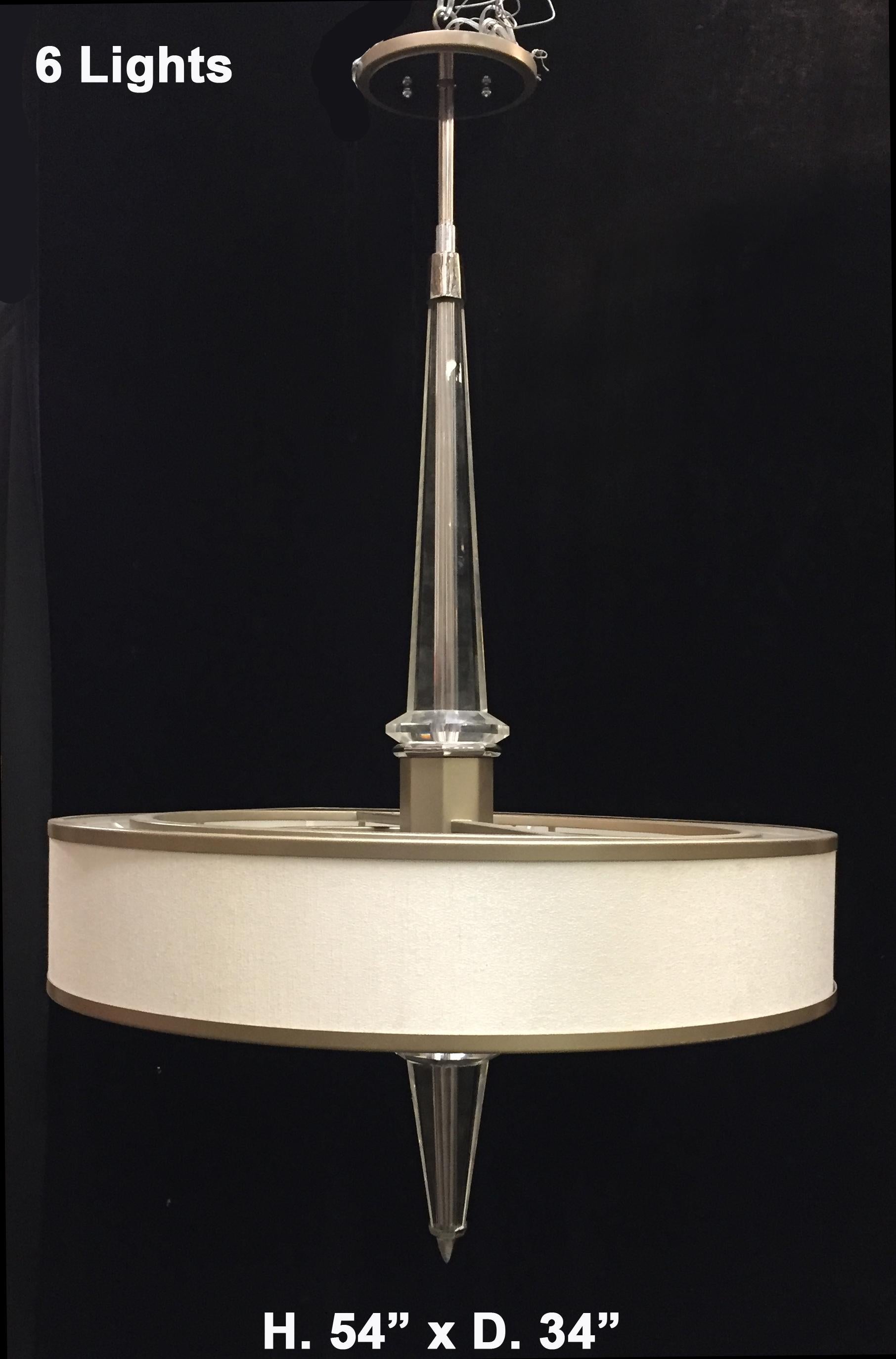 Lovely modern style lucite chandelier.
Late 20th century. 
The chandelier is centered by an obelisk-shaped faceted Lucite central shaft, surrounded with a round shade containing 6 lights
Electrified for the U.S. market. 
Measures: H. 54