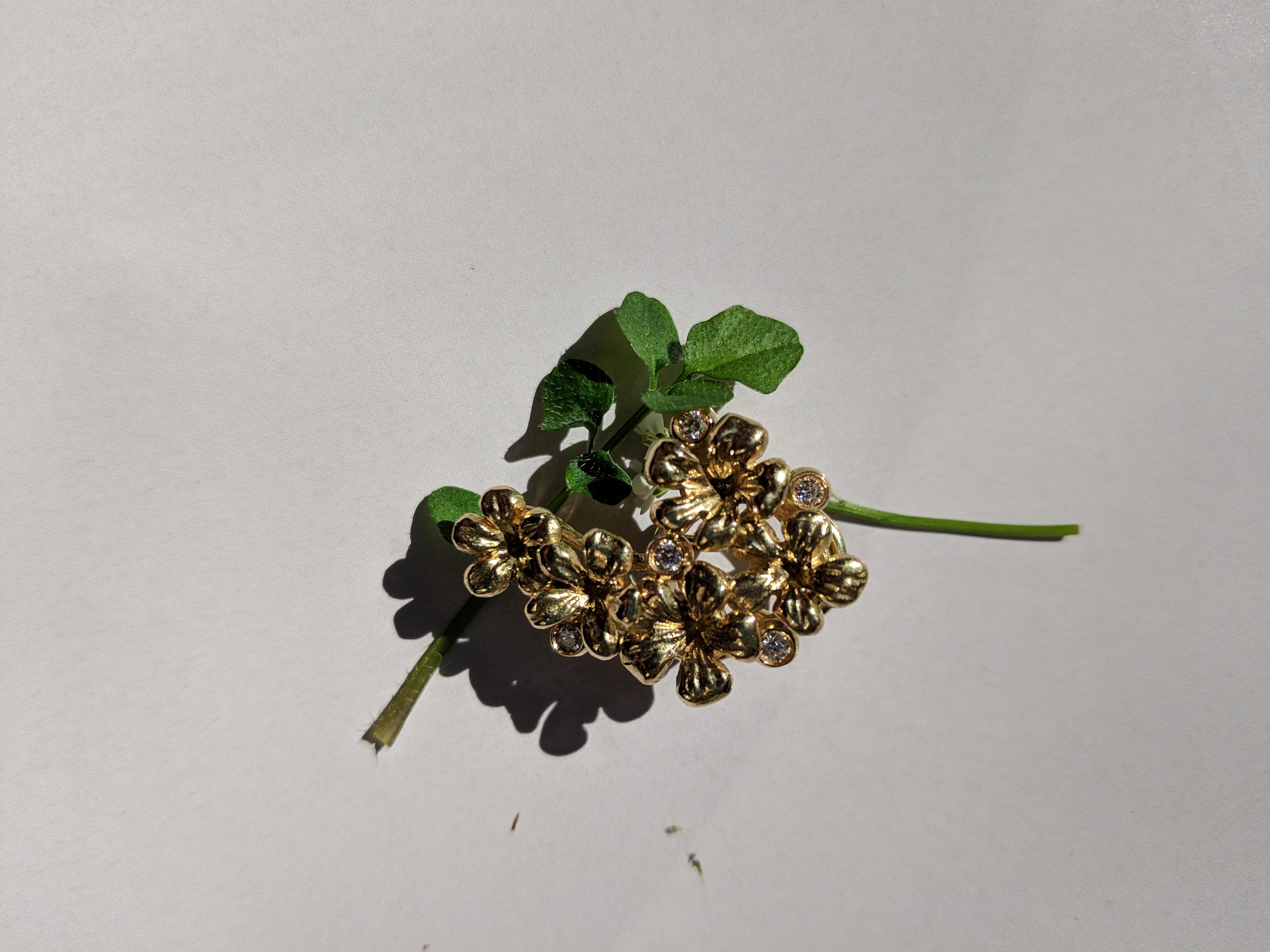 Dieses moderne Collier mit Blumenanhänger aus 18 Karat Gelbgold ist mit 5 runden Diamanten und einem abnehmbaren Prasiolith (natürlicher grüner Quarz) verziert. Diese Schmuckkollektion wurde im November in der Vogue UA vorgestellt.
Das Stück hat