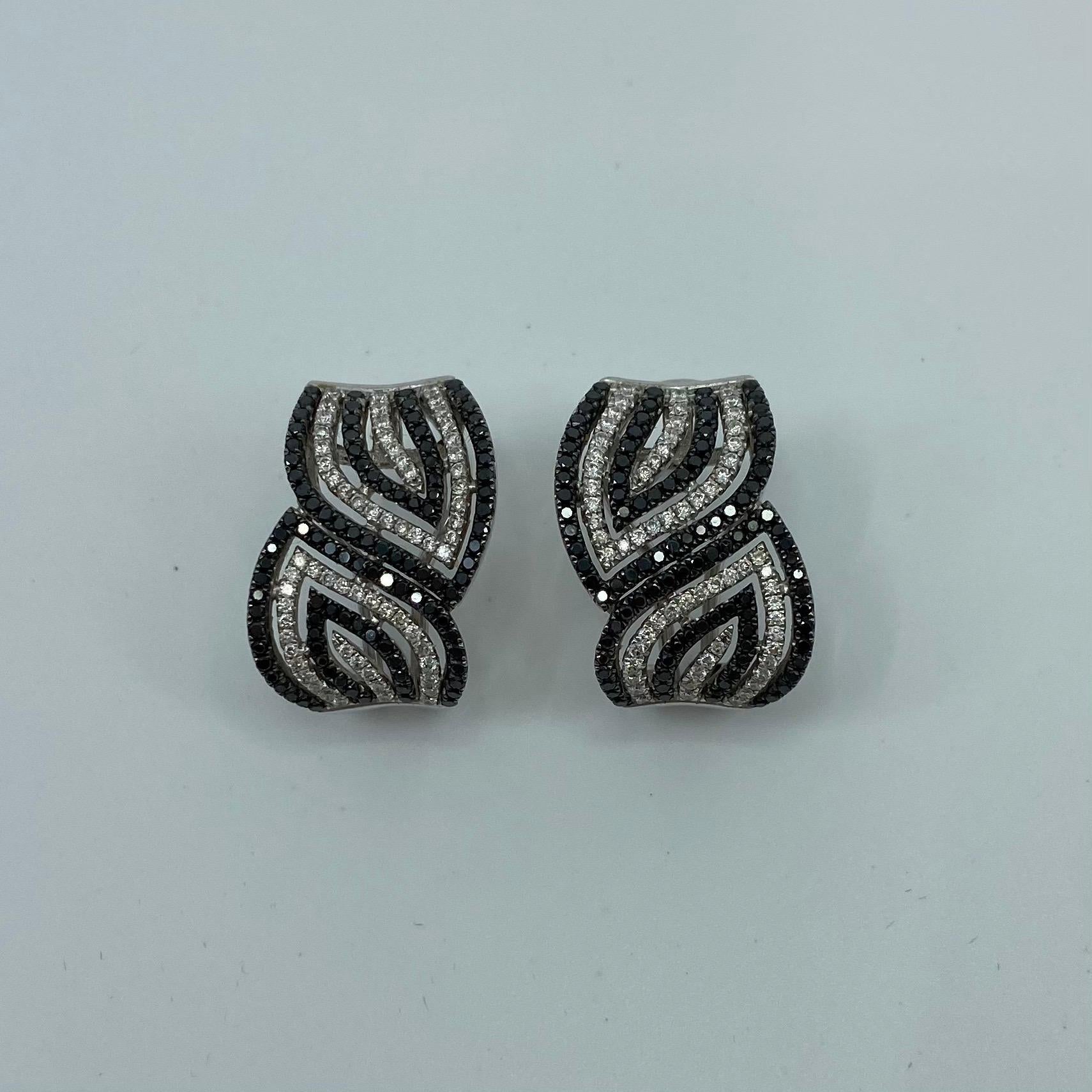 Modern Black & White Diamond 18 Karat White Gold Swirl Earrings.

Beautiful and stylish black and white diamond earrings with a unique modern swirl look. We also have a matching ring for these.

Earrings have a strong clip with earring posts.
Fully