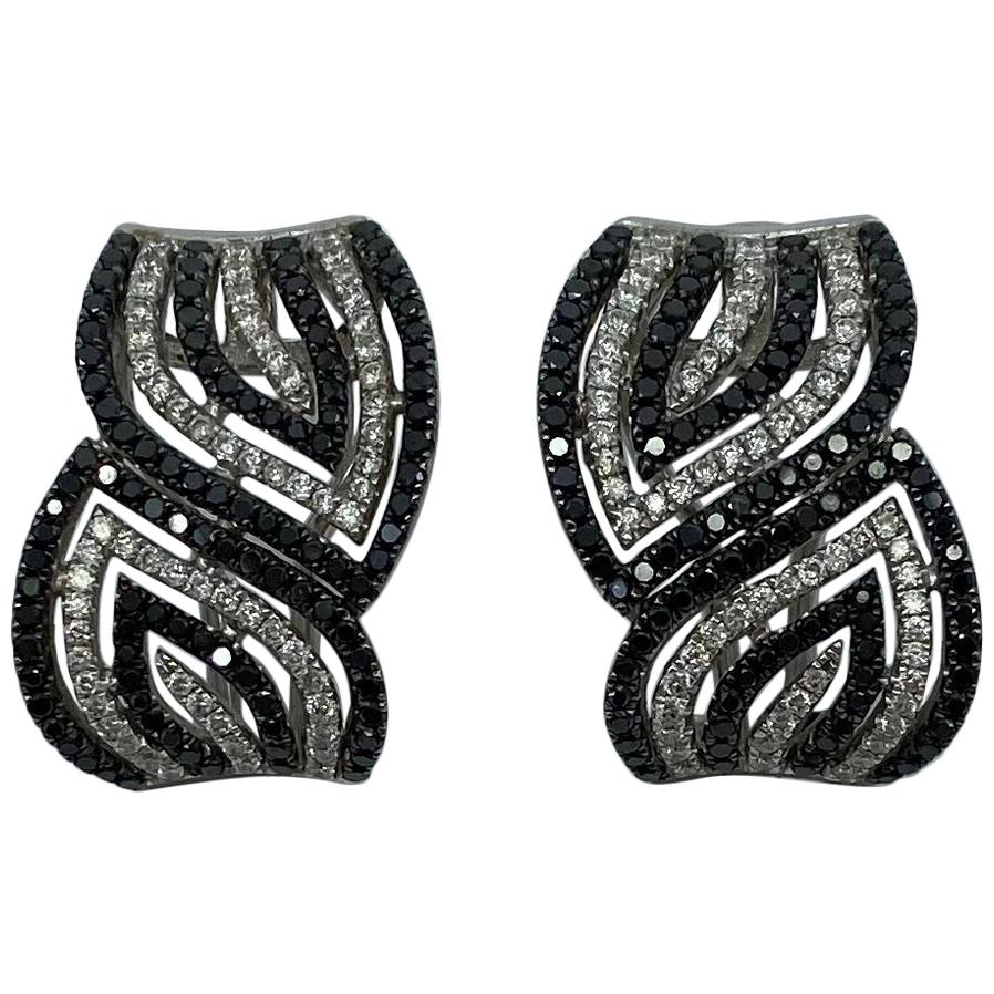 Clous d'oreilles modernes et élégantes en forme de tourbillon en or blanc 18 carats avec diamants noirs et blancs en vente
