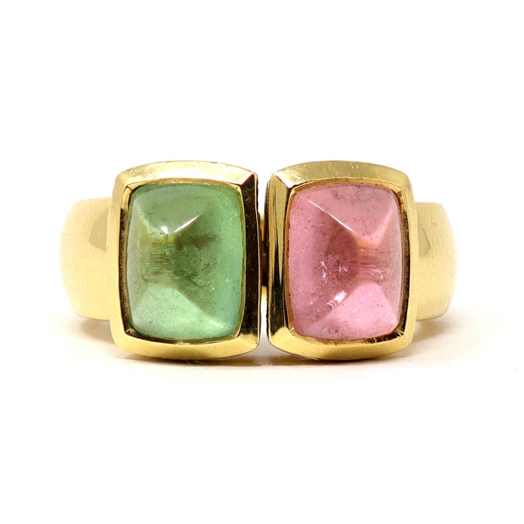 A Modern two-stone ring circa 1980, set in 18K yellow gold. This statement cocktail ring features a pink and green cabochon tourmalines cut in sugarloaf shape and set in an 18 karat yellow gold mount. The gross weight is 15.4 grams. The size is 9 ¼.